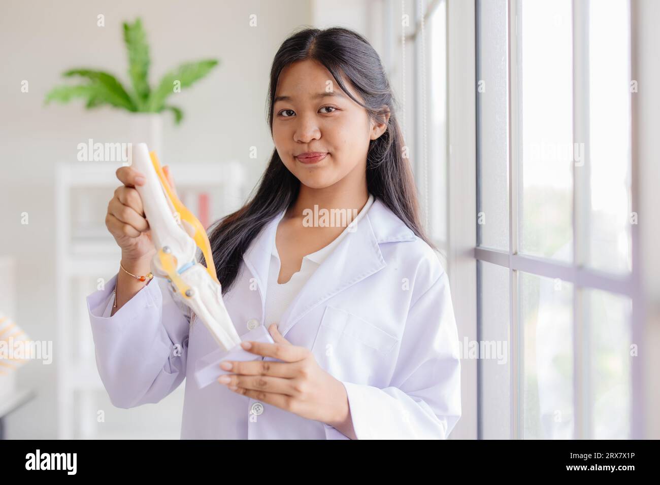 Junger asiatischer Rollenspiel als Arzt, der im Schullabor glücklich lächelt und Platz für Text hat Stockfoto