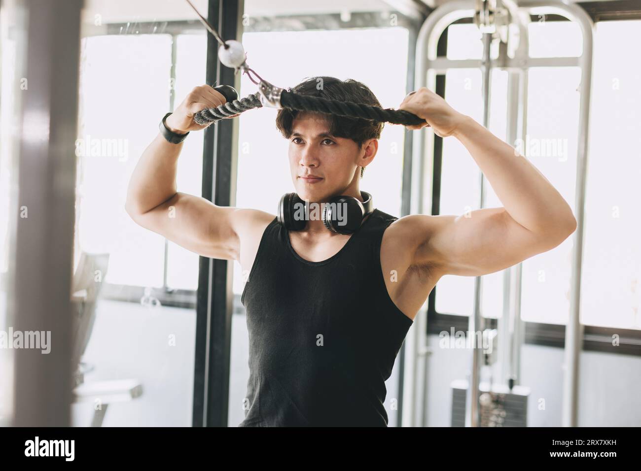 Asiatische Fitness männliche Pull Übungen für Brust und Schulter Muskelkraft Training im Sport Club Stockfoto