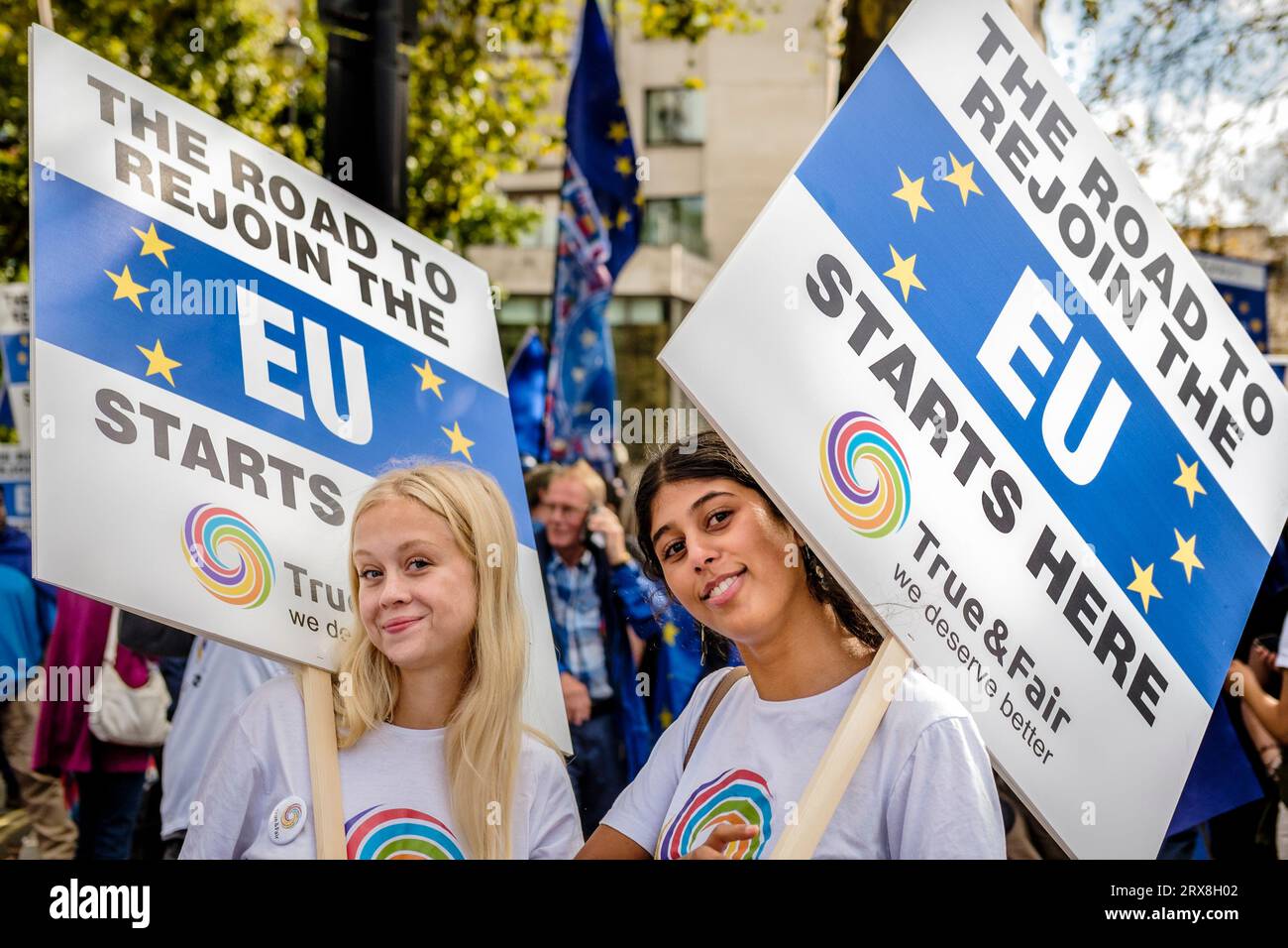 23. September 2023. London, Großbritannien. Rund 3.000 EU-freundliche Aktivisten und Unterstützer nehmen an einem nationalen Wiederzusammenkommensmarsch und einer Kundgebung im Zentrum Londons Teil. Die Aktivisten behaupten, der Brexit sei eine Katastrophe für das Vereinigte Königreich gewesen und fordern, dass das Land seine Mitgliedschaft in der Europäischen Union wiederaufbaut. Abgebildet: Zwei junge EU-freundliche Unterstützerinnen tragen Plakate, die von der True & Fair-Partei auf dem National Rejoin March im Zentrum Londons für einen Wiedereintritt der EU entworfen wurden. Stockfoto