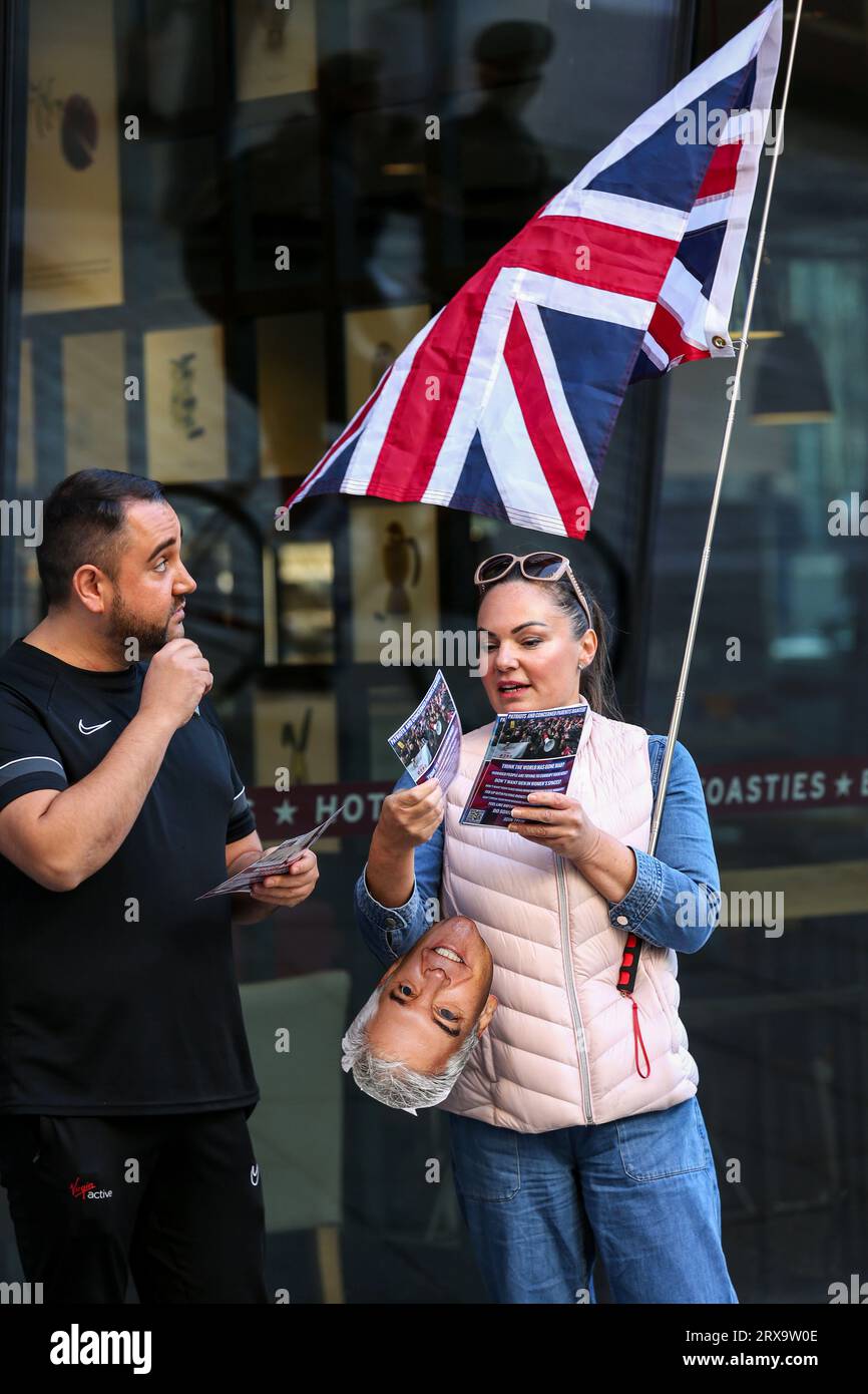 London, Großbritannien. September 2023. Ein Demonstrant mit einer gewerkschaftsflagge spricht mit einem Mitglied der Öffentlichkeit und verteilt ein Faltblatt. Unterstützer von Turning Point demonstrieren in der Nähe von Bleecker Burger, als sie eine umstrittene Drag Queen Aida H Dee planten, um Kindern als Teil der Drag Queen Story Hour-Serie vorzulesen. Turning Point sieht diese Ereignisse als Kinderpflege und fühlt sich, dass Drag Queens Unterhaltung für Erwachsene sind und Kindern nicht ausgesetzt werden sollten. Der Protest war erfolgreich, um die Lesung zu beenden. Quelle: SOPA Images Limited/Alamy Live News Stockfoto