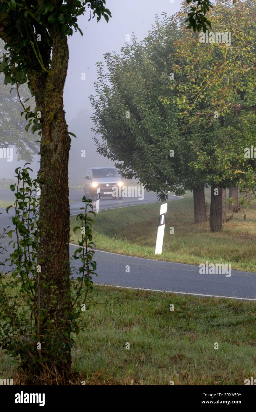 24. September 2023, Bayern, Dürrnhof: Ein Auto fährt mit Lichtern auf einer nebeligen und kurvenreichen Straße. Heutzutage besteht wieder ein erhöhtes Unfallrisiko aufgrund schlechter Sicht. Foto: Pia Bayer/dpa Stockfoto