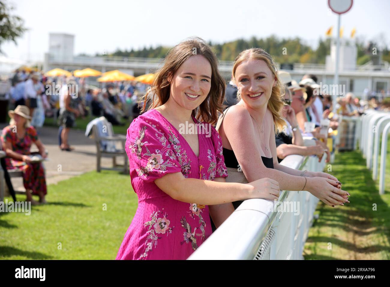 Zwei Frauen auf dem Bild, die das Pferderennen auf der Goodwood Racecourse in Chichester, West Sussex, Großbritannien, genießen. Stockfoto