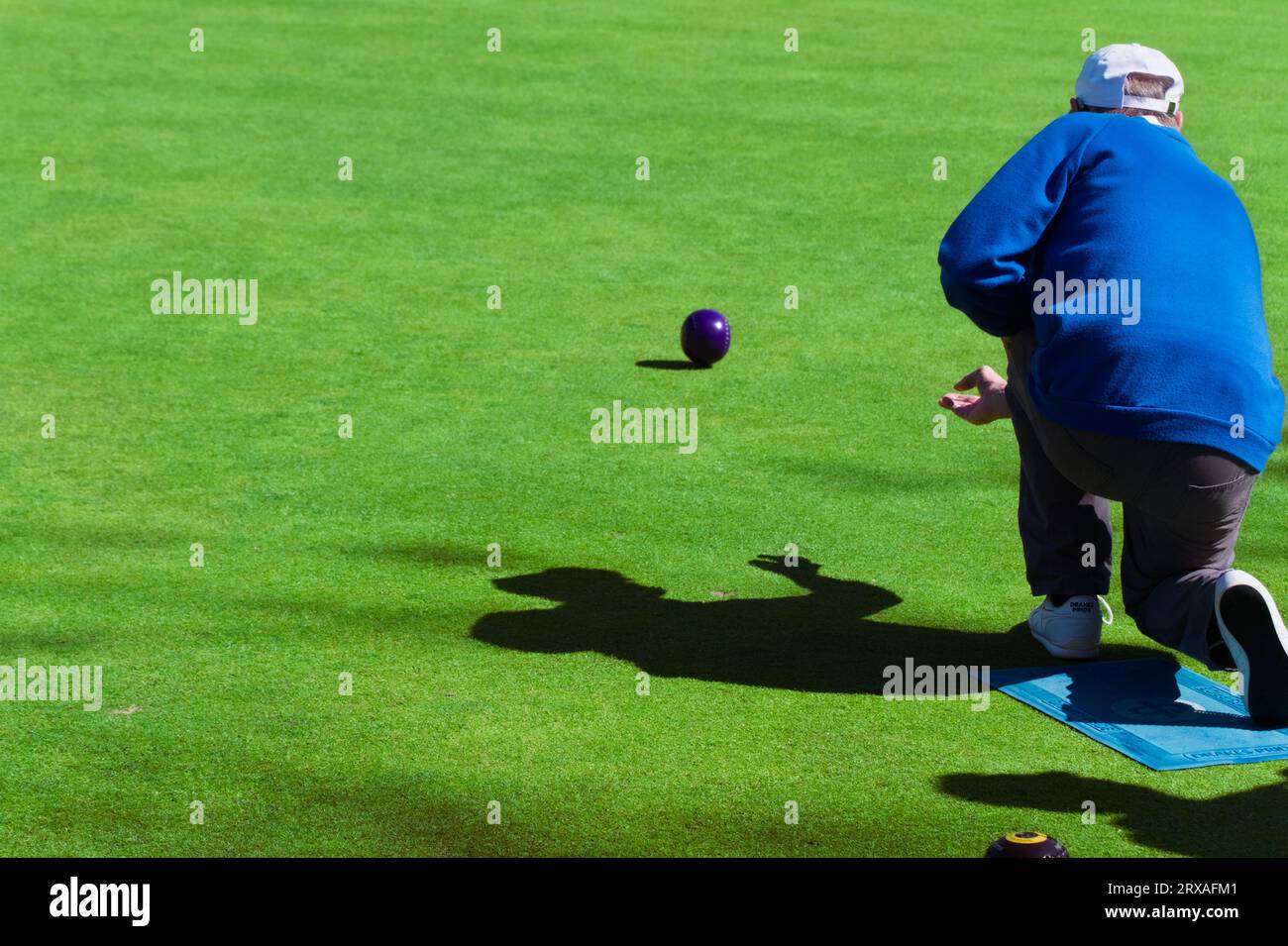 Älterer Mann, der Rasen spielt Green Bowls Bowling Eine Rasenschale, Highcliffe, großbritannien Stockfoto