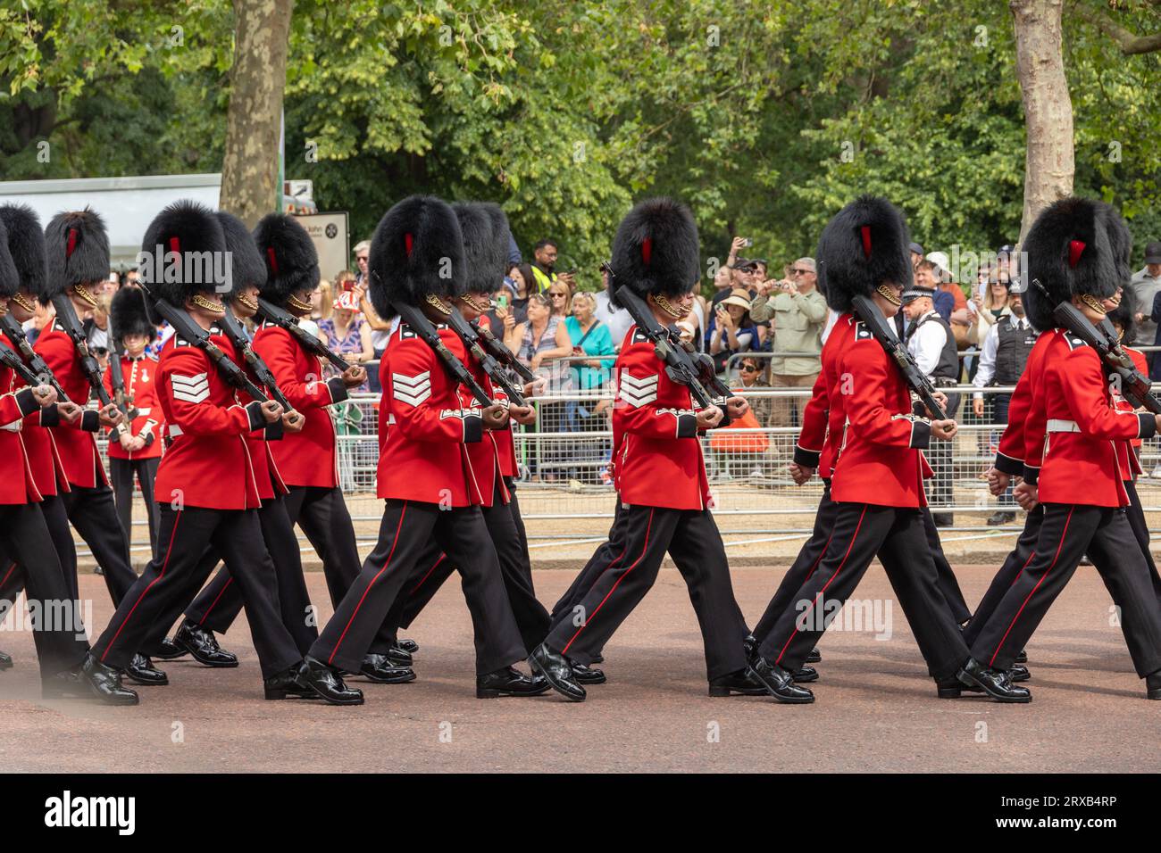 Juni, König Charles Geburtstag, Trooping the Colour Parade. Königliche Wachen mit Bärenfellmützen, die während der Parade marschieren. Umstehende beobachten. Stockfoto