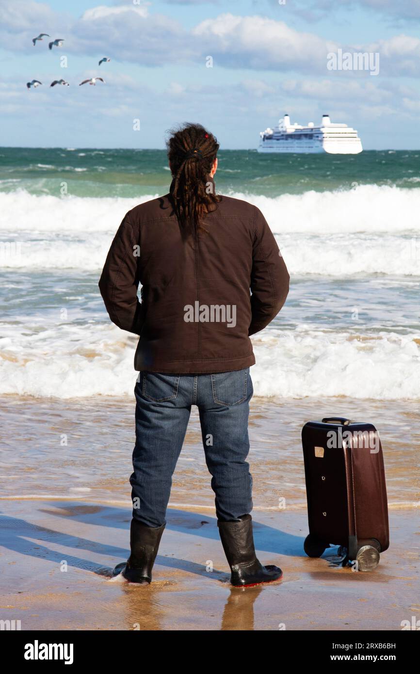 Mann mit Koffer, der auf das Kreuzfahrtschiff schaut Stockfoto