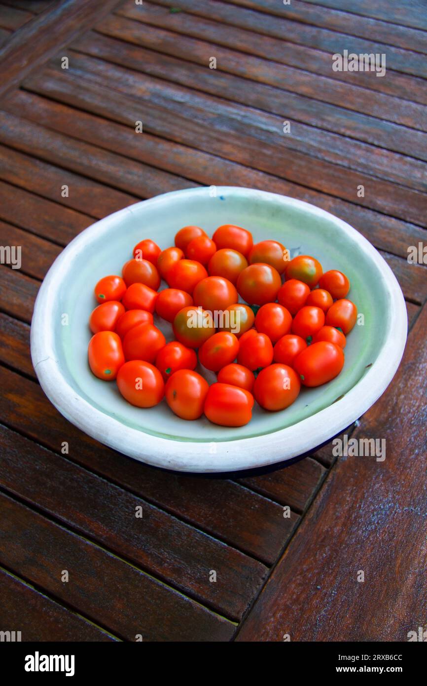 Kirschtomaten in einem Gericht auf einem Holztisch Stockfoto