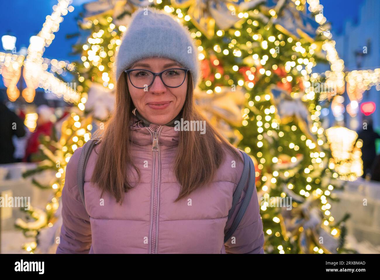 Tolle Urlaubsmomente: Glückliche Frau posiert in der festlichen Silvesterstraße. Stockfoto