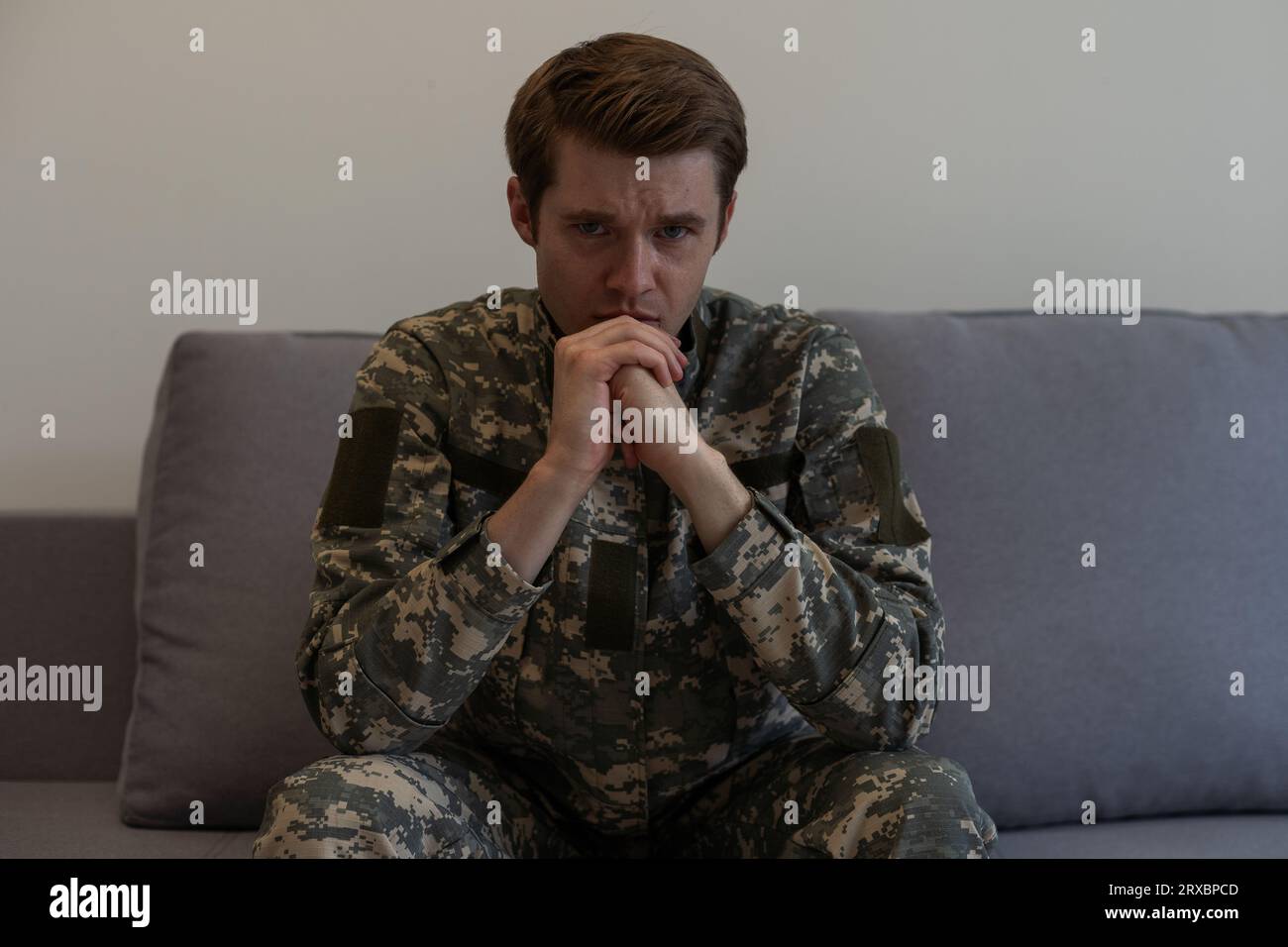 Nervöse männliche Militärangehörige leiden an Depressionen, allein zu Hause sitzen, PTBS-Konzept. Stockfoto