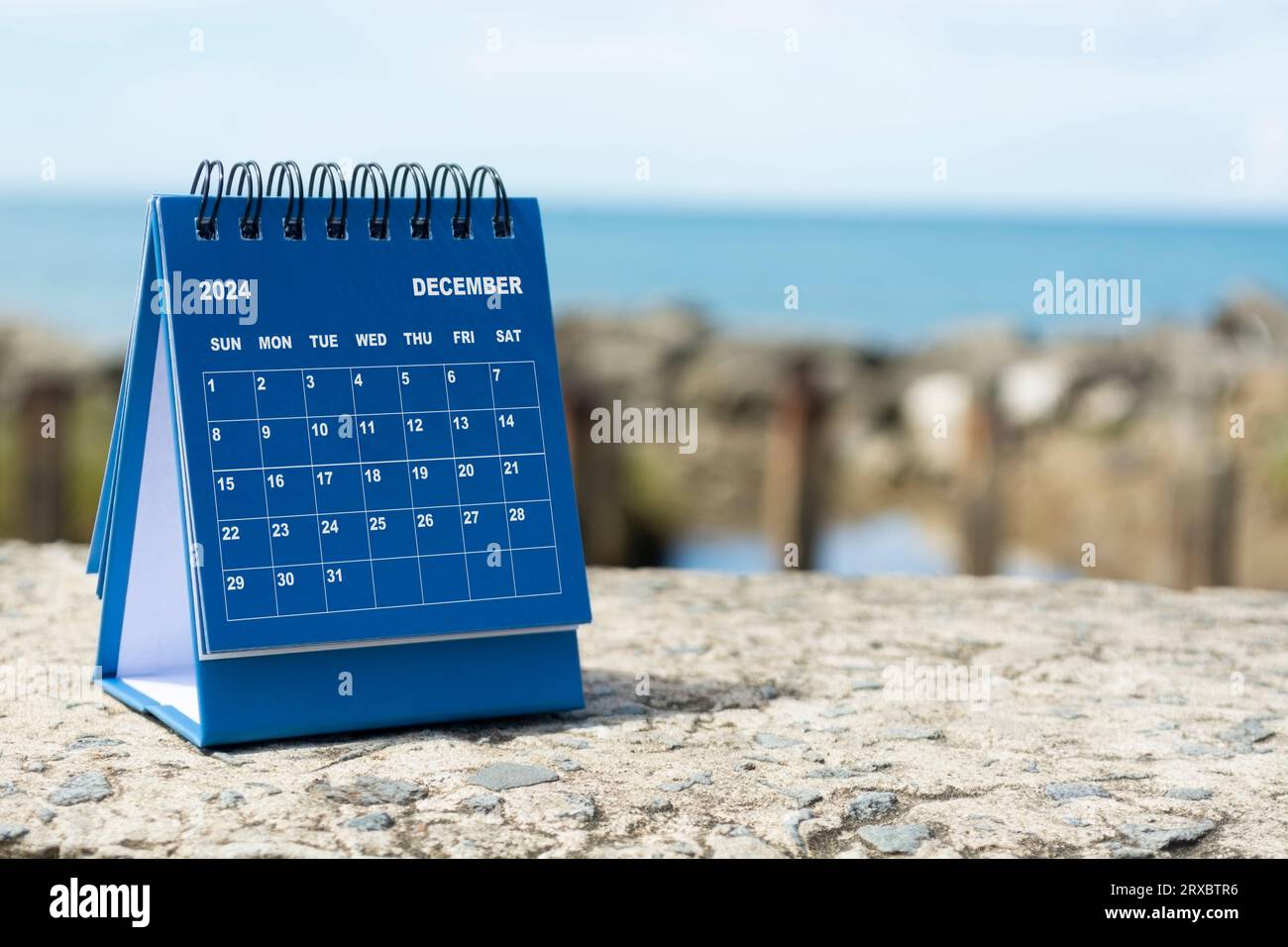 Blauer Kalender vom Dezember 2024 auf verschwommenem Hintergrund des blauen Ozeans. Neujahrskonzept 2024 Stockfoto