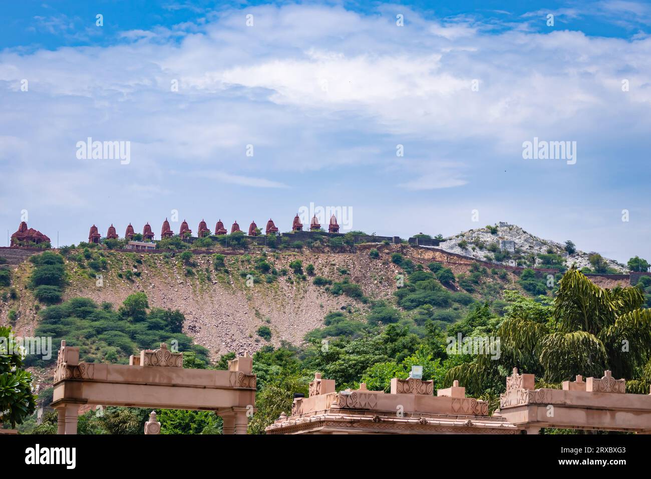 Künstlerische Serie oder jain-Tempel aus rotem Stein auf der Bergspitze mit hellblauem Himmel am Morgen. Das Bild wird in Shri Digamber Jain Gyanoday Tirth Kshetra aufgenommen. Stockfoto