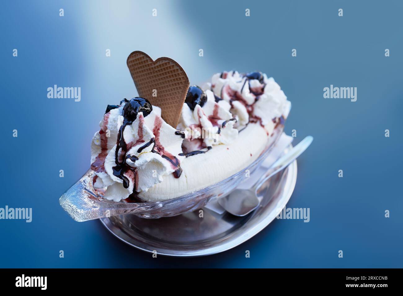 Bananensplittereis in einem Teller, isoliert auf blauem Hintergrund Stockfoto