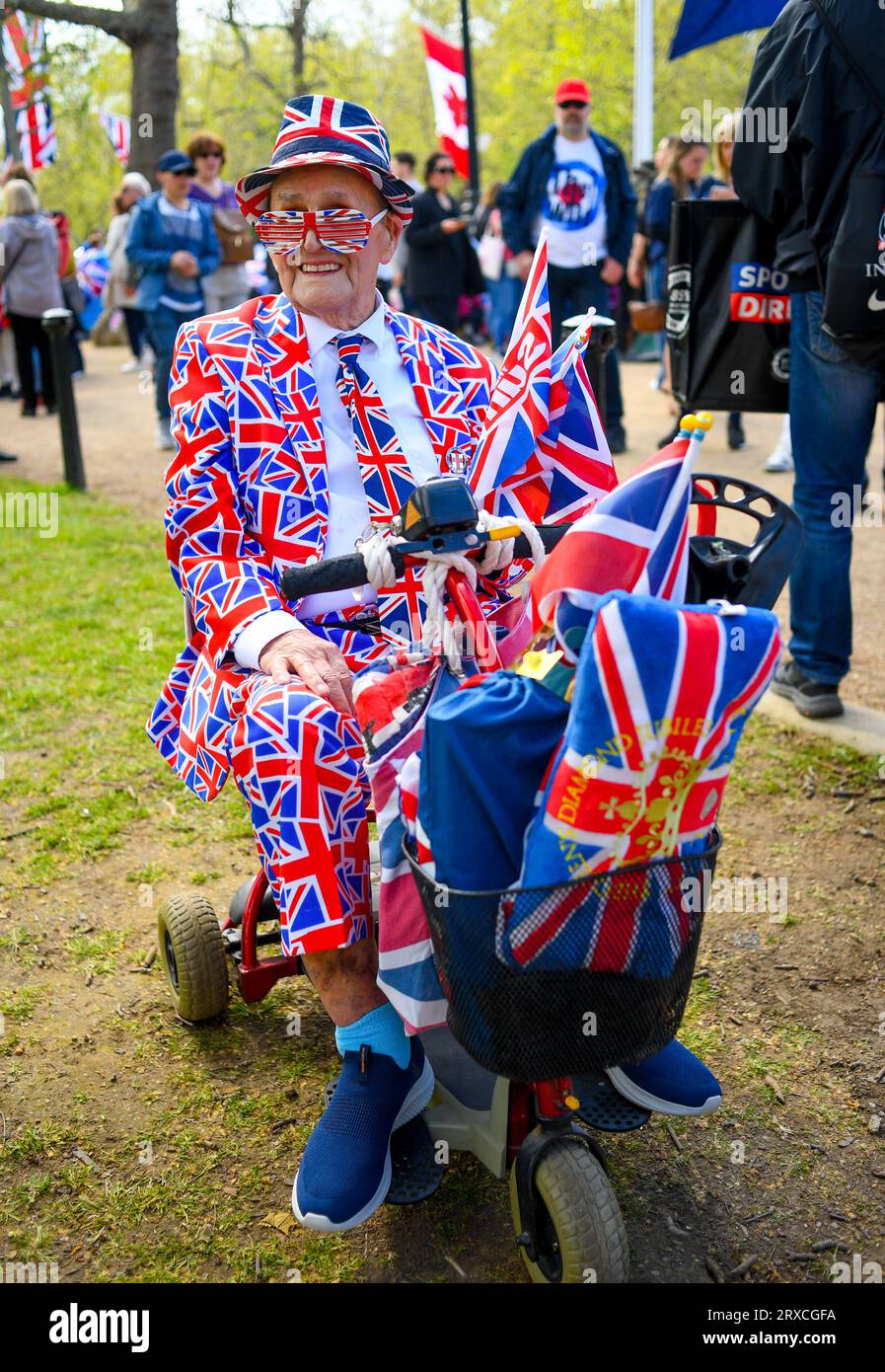 Ein OAP in Unions-Jack-Kleidung in einem Mobilitätsroller in der Mall London England anlässlich der Krönung von König Charles. Stockfoto