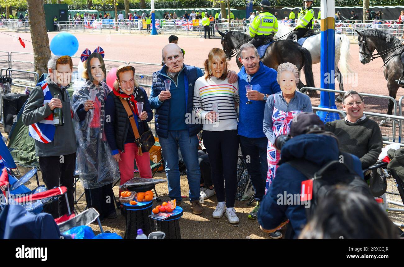 Eine Familiengruppe posiert und feiert mit königlichen Masken in der Mall, nachdem sie einen Tag vor der Krönungsparade einen Platz gesichert hat. Stockfoto