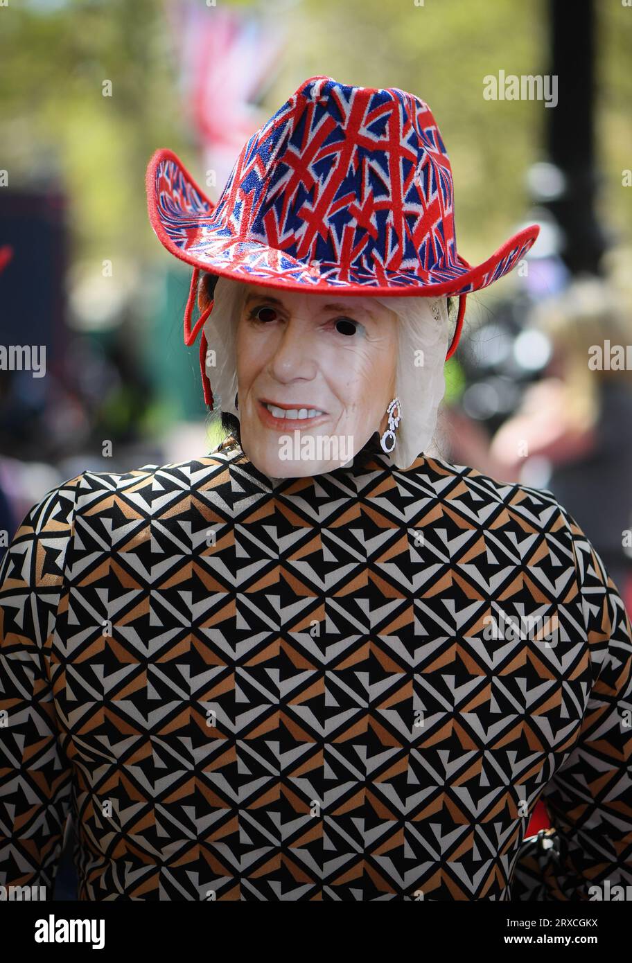 Eine Queen Camilla Maske auf dem Hinterkopf mit einem Union Jack Hut während der Krönungsfeier in London in der Mall. Stockfoto