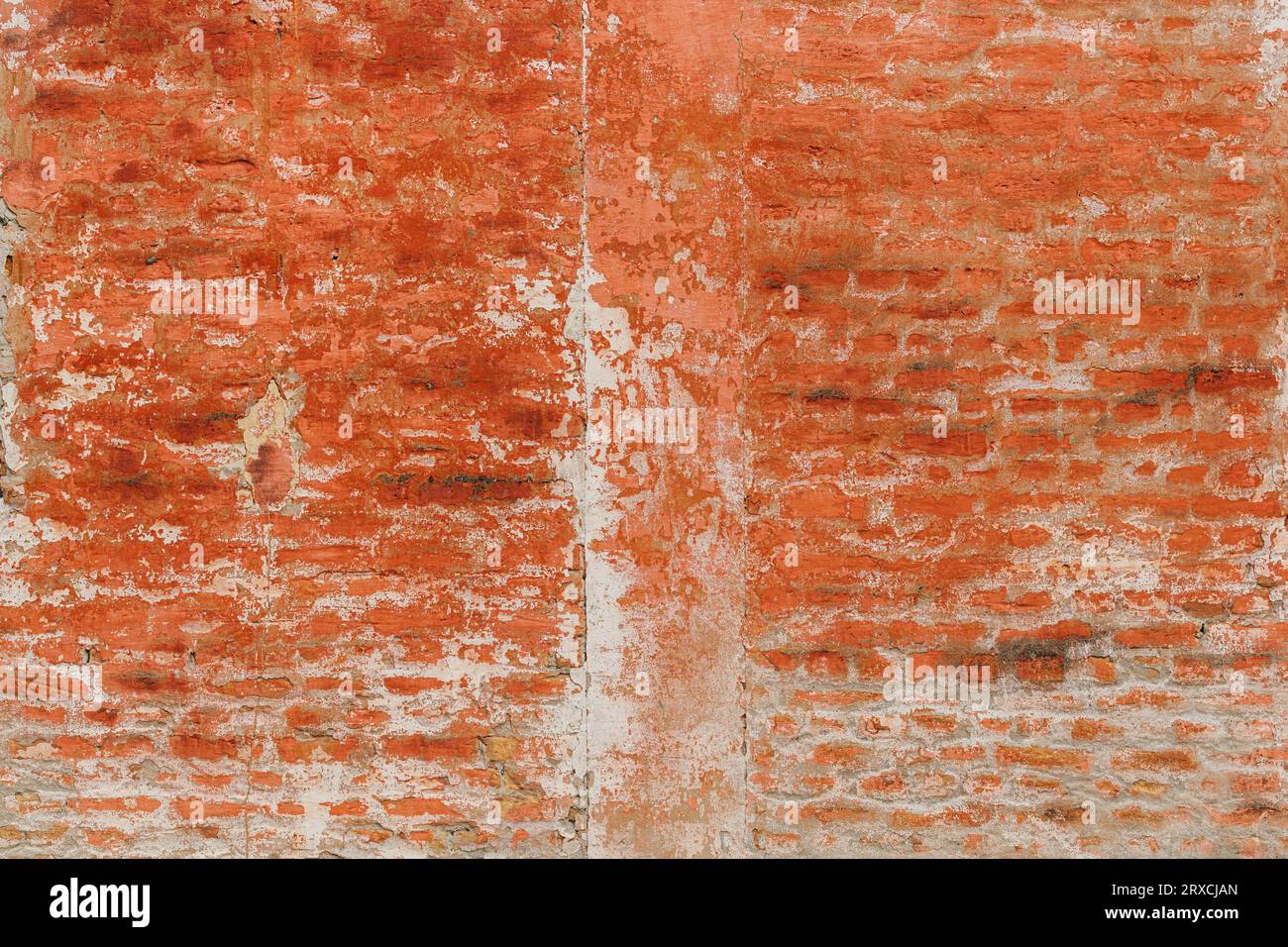 Alte Ziegelwand mit abblätternder roter Farbe und verwittertem Altmörtel als Hintergrund mit einzigartiger Textur und Muster, abstrakter Grunge-Hintergrund Stockfoto