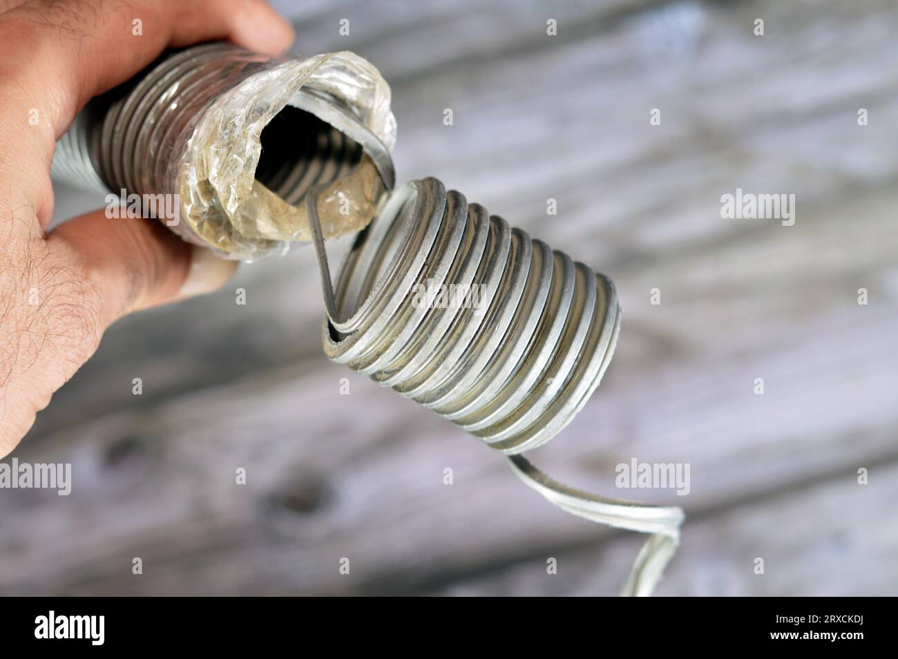 Ein gebrochener flexibler Schlauch aus einem Staubsauger, minderwertigen Materialien und Wartungskonzept, ein Staubsauger ist eine elektrische Hausmaschine Stockfoto