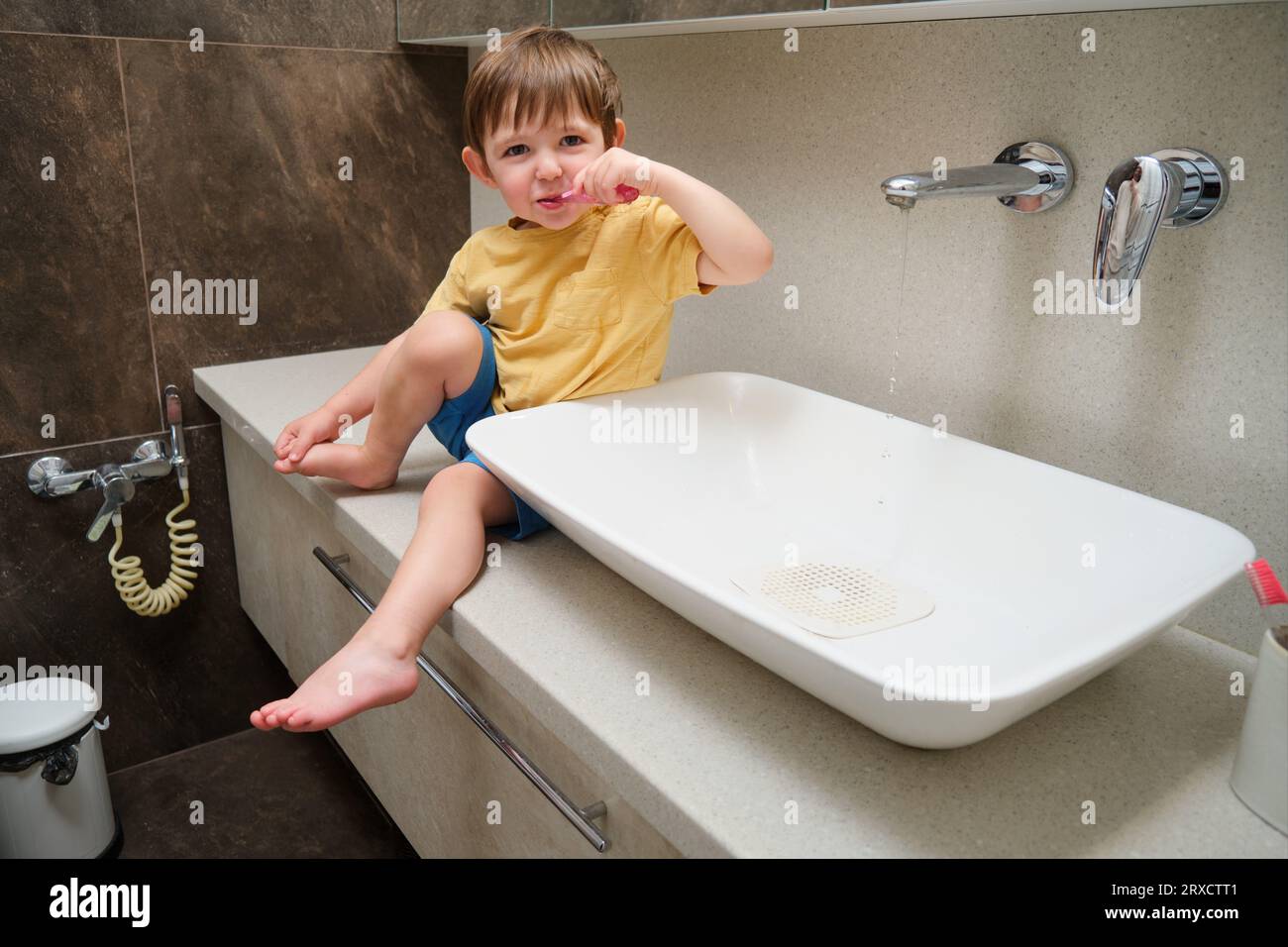 Kleiner kleiner Junge, der im Badezimmer die Zähne putzt. Kind im Alter von zwei Jahren (zweijähriger Junge) Hygienekonzept. Stockfoto