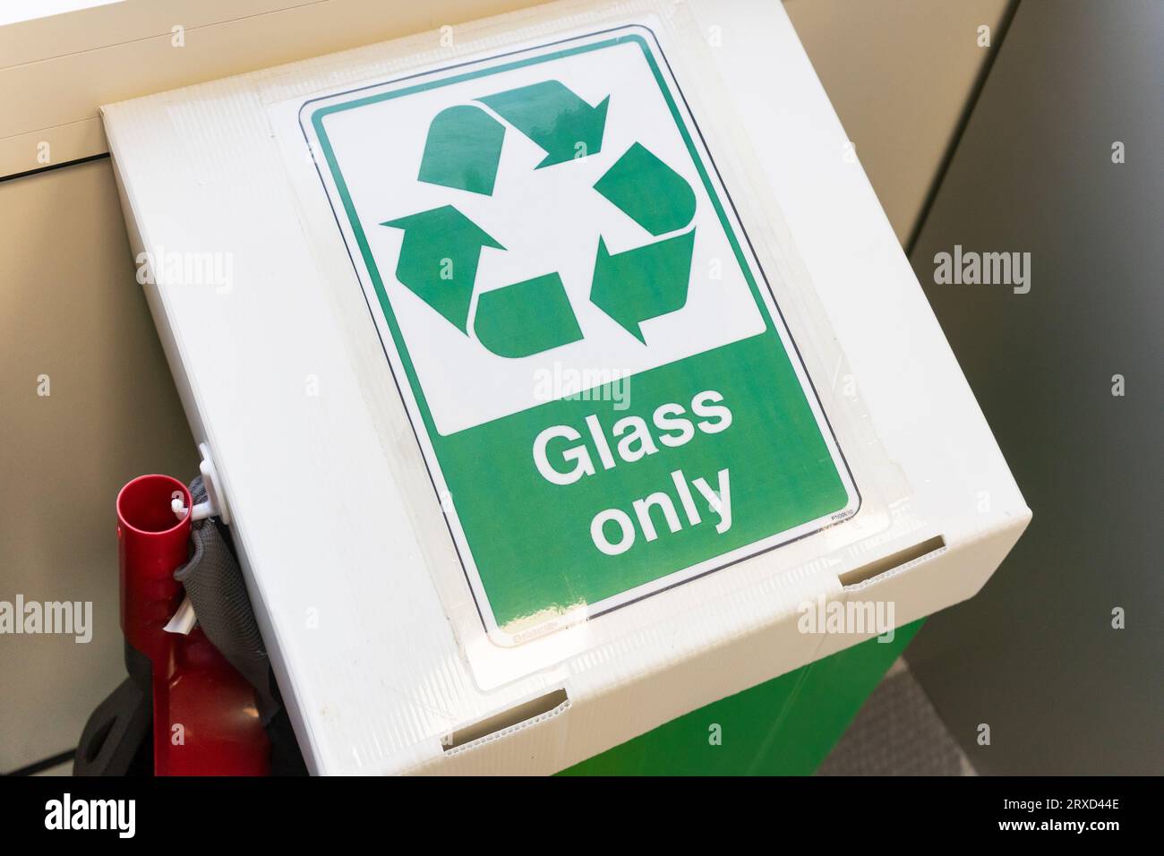 Eine Recyclingbox aus Glas in einem britischen Büro mit einem Recycling-Symbol. Konzept: Unternehmensrecycling, umweltfreundliche Referenzen, Bürorecycling, Glasentsorgung Stockfoto