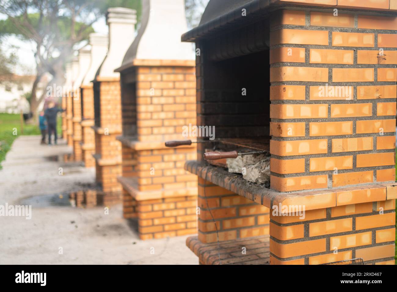 Kamin zum Grillen aus Ziegeln. Im Freien kann man Fleisch und Burger grillen. Lange Reihe von Kaminen und Raucheröfen im Freien. Öffentlicher Ort für Grillpartys an der frischen Luft. Stockfoto