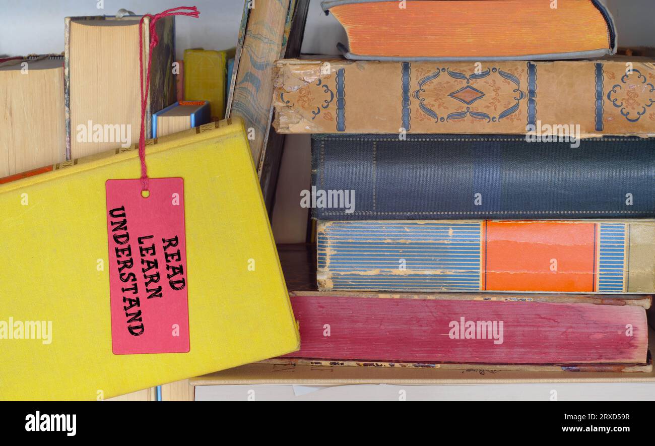 Stapel Bücher in einem Bücherregal mit dem Slogan Learn Understanding. Zurück zur Schule, Bildung, Wissenskonzept. Stockfoto