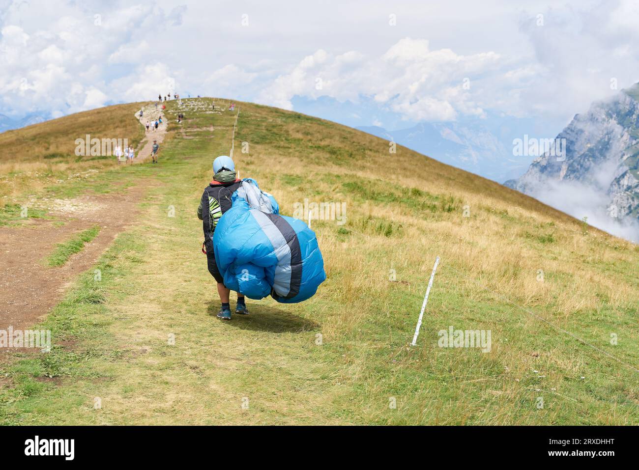 Paraglider-Pilot mit seinem Paraglider auf dem Weg zum Monte Baldo am Gardasee bei Malcesine Stockfoto