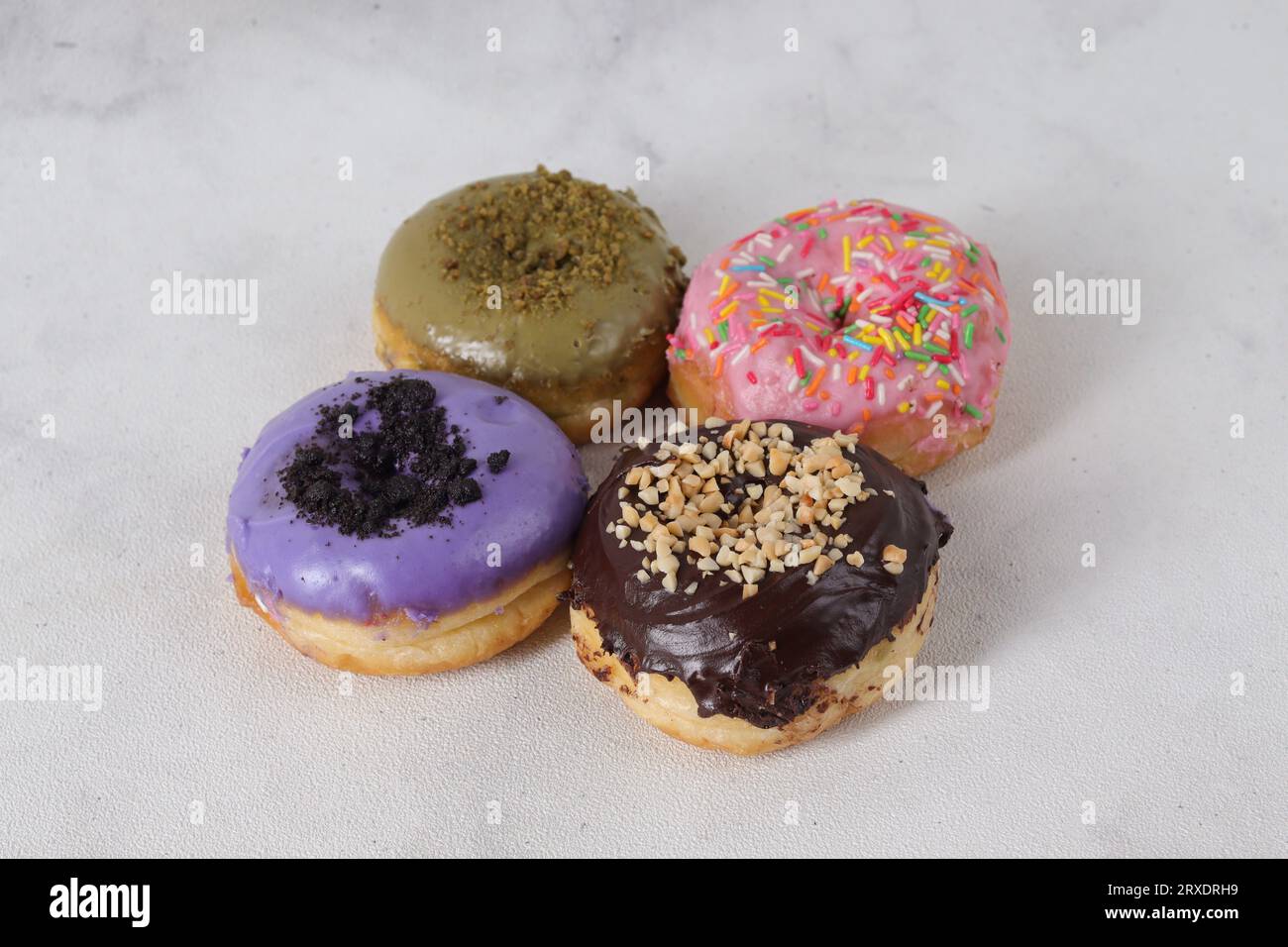 Köstliche süße Donuts mit verschiedenen Aromen auf einem Tisch. Isoliertes Bild auf weißem Hintergrund Stockfoto