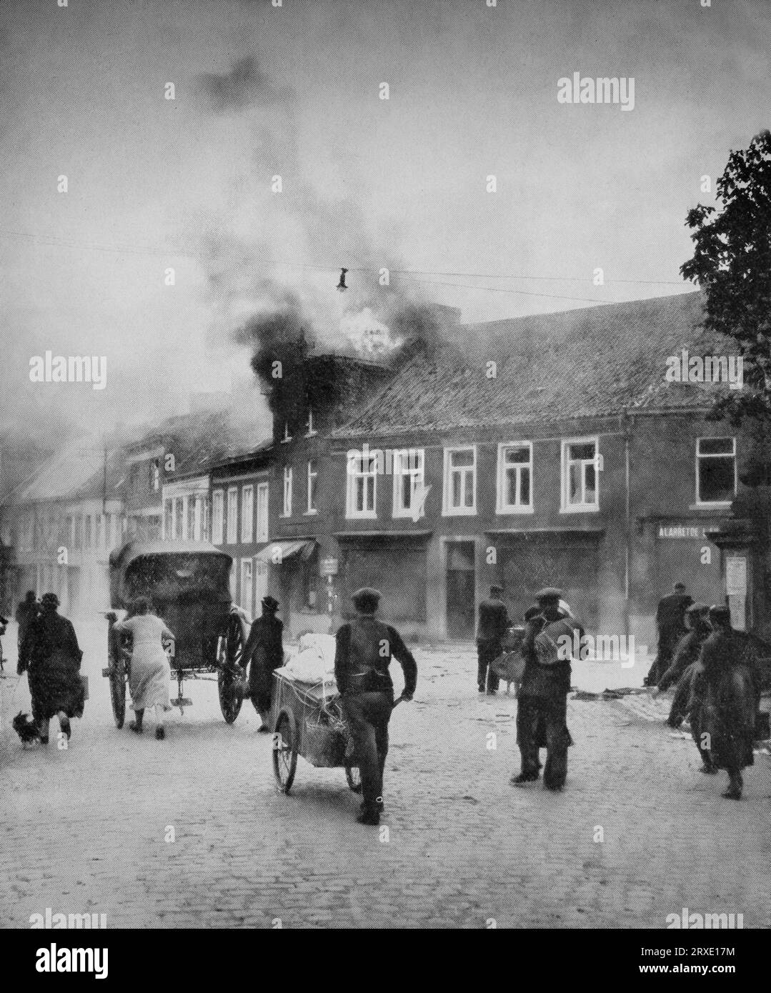 Am 10. Und 11. Mai 1940, während des Zweiten Weltkriegs, durchquerten die Flüchtlinge ein brennendes Dorf in den unteren Ländern. Stockfoto
