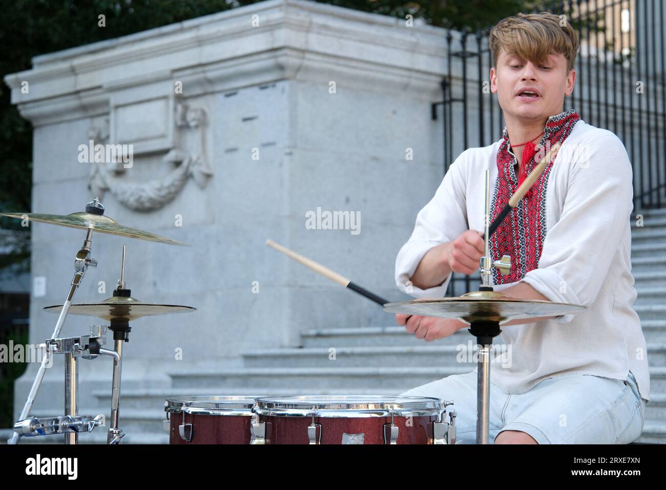 Spielen Sie meisterhaft die Trommel der schöne junge Mann von europäischem Aussehen in ukrainischen bestickten Hemden Nationalkleidung der Ukraine spielt die Trommel wehende Sticks. Kraft der Glücklichkeits-Professionalität Stockfoto