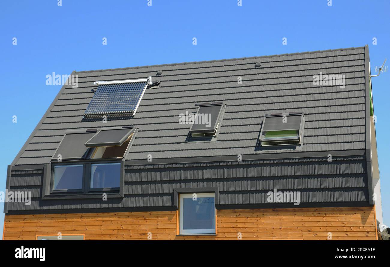 Bei der Solarwasserheizung auf dem Hausdach (SWH) wird das Wasser durch Sonnenlicht mit einem solaren thermischen Kollektor erwärmt. Dachfenster mit einziehbarem Dachfenster Stockfoto