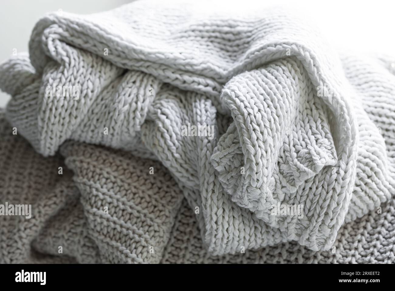 Strickpullover oder Schal in warmem Grau, gemütliche Komposition in der häuslichen Atmosphäre. Stockfoto