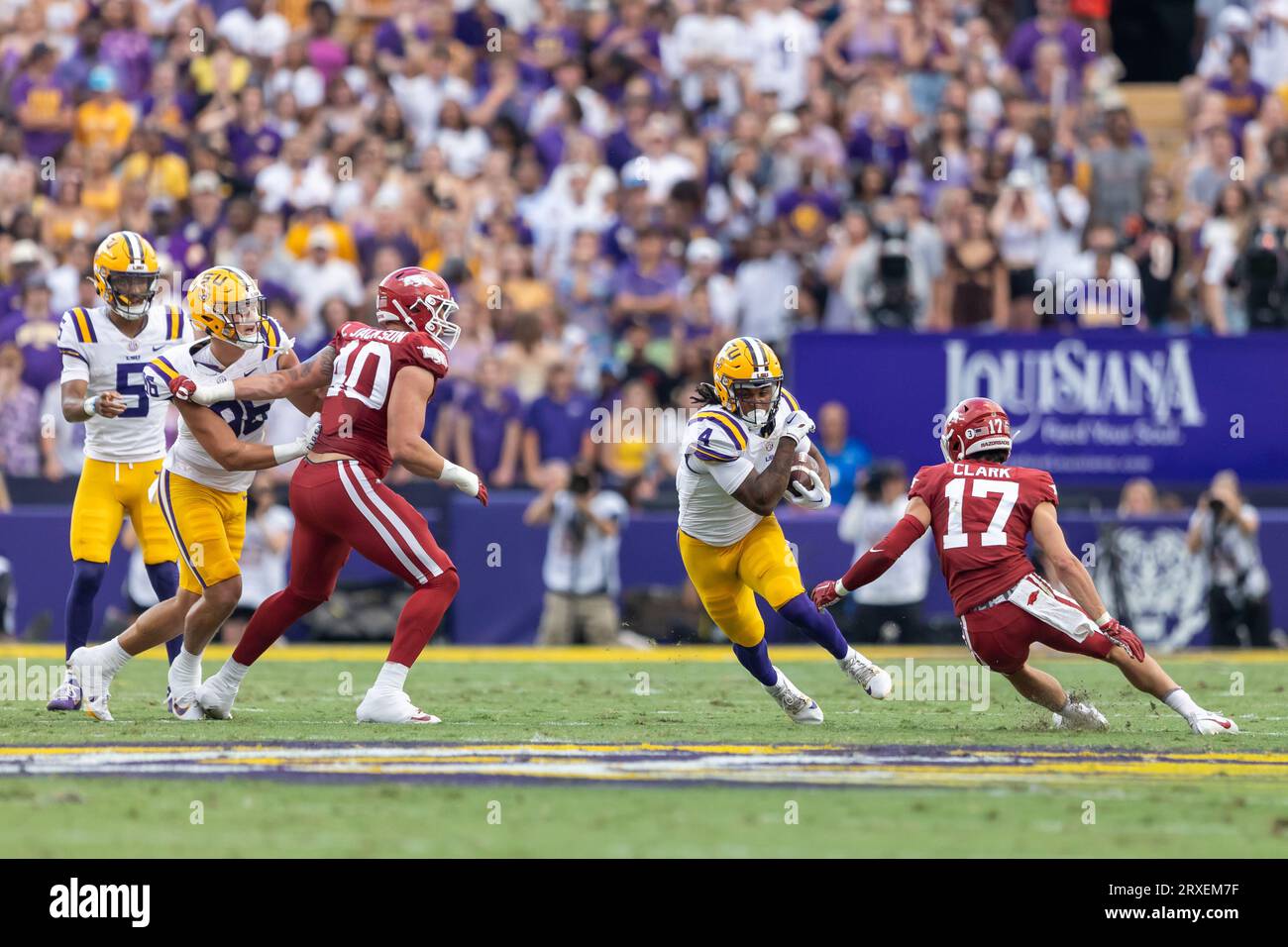 LSU Tigers Running Back John Emery Jr. (4) trägt den Ball als Arkansas Razorbacks Defensive Lineman Landon Jackson (40) und Defensive Back Hudson CLA Stockfoto