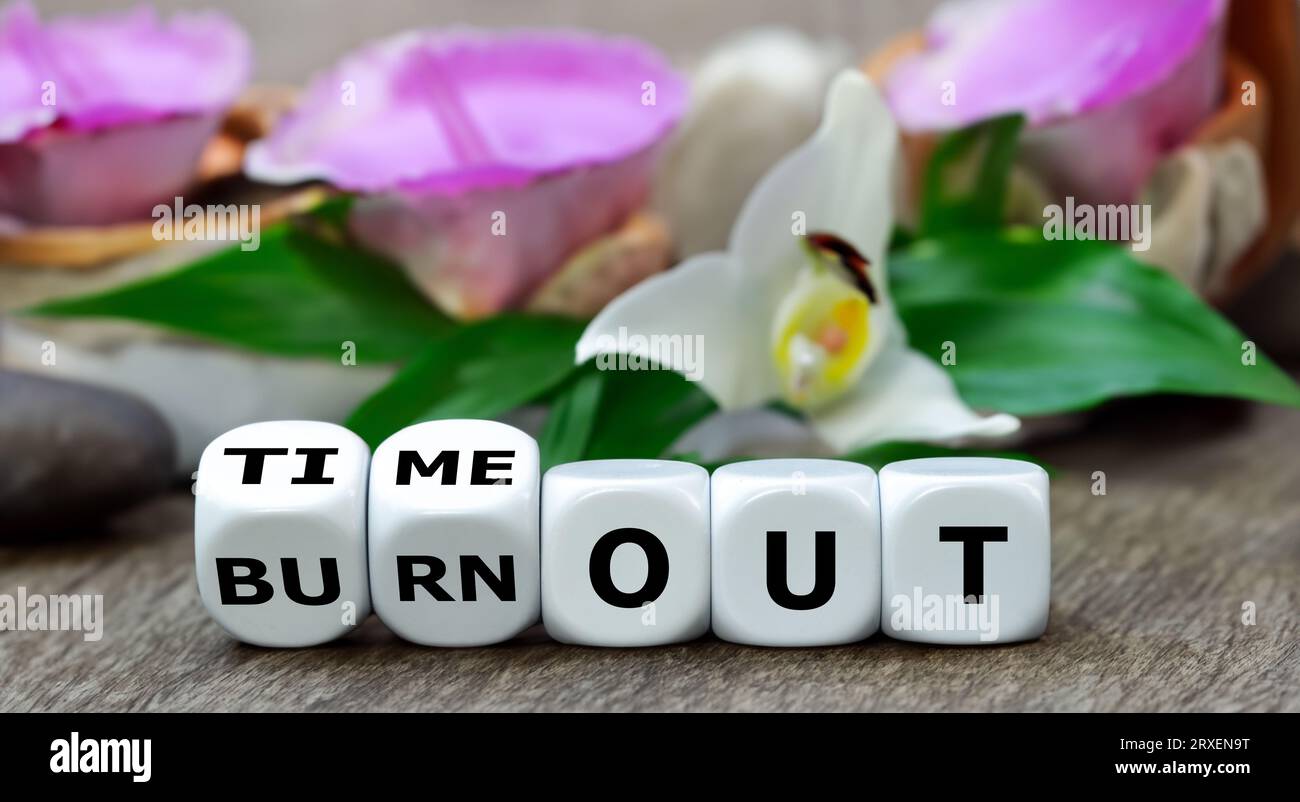 Symbol für eine Pause. Die Hand würfelt und ändert den Ausdruck „Burnout“ in „Timeout“. Stockfoto