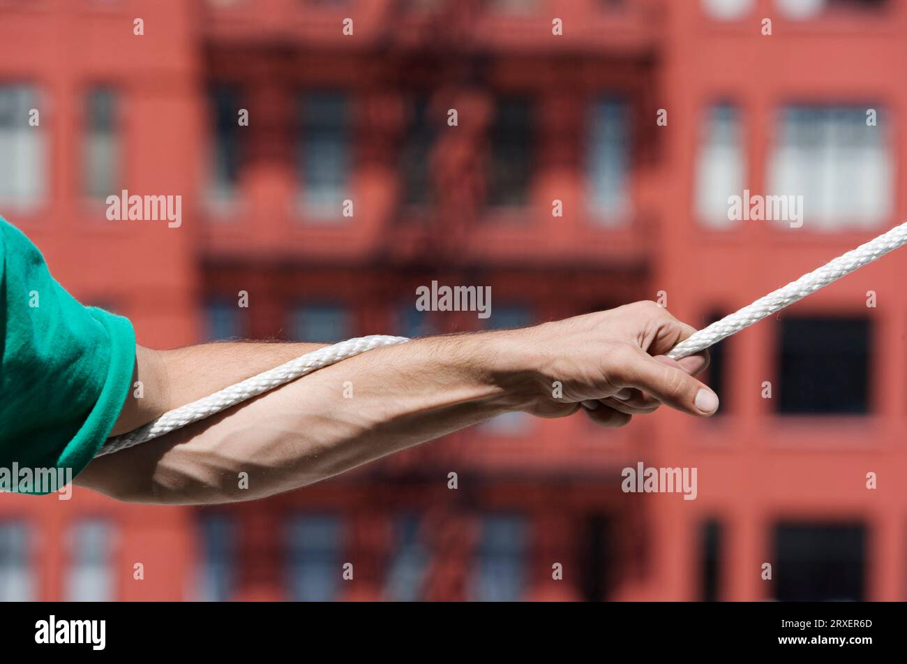 Der Arm eines Mannes, der an einem Seil zieht. Stockfoto