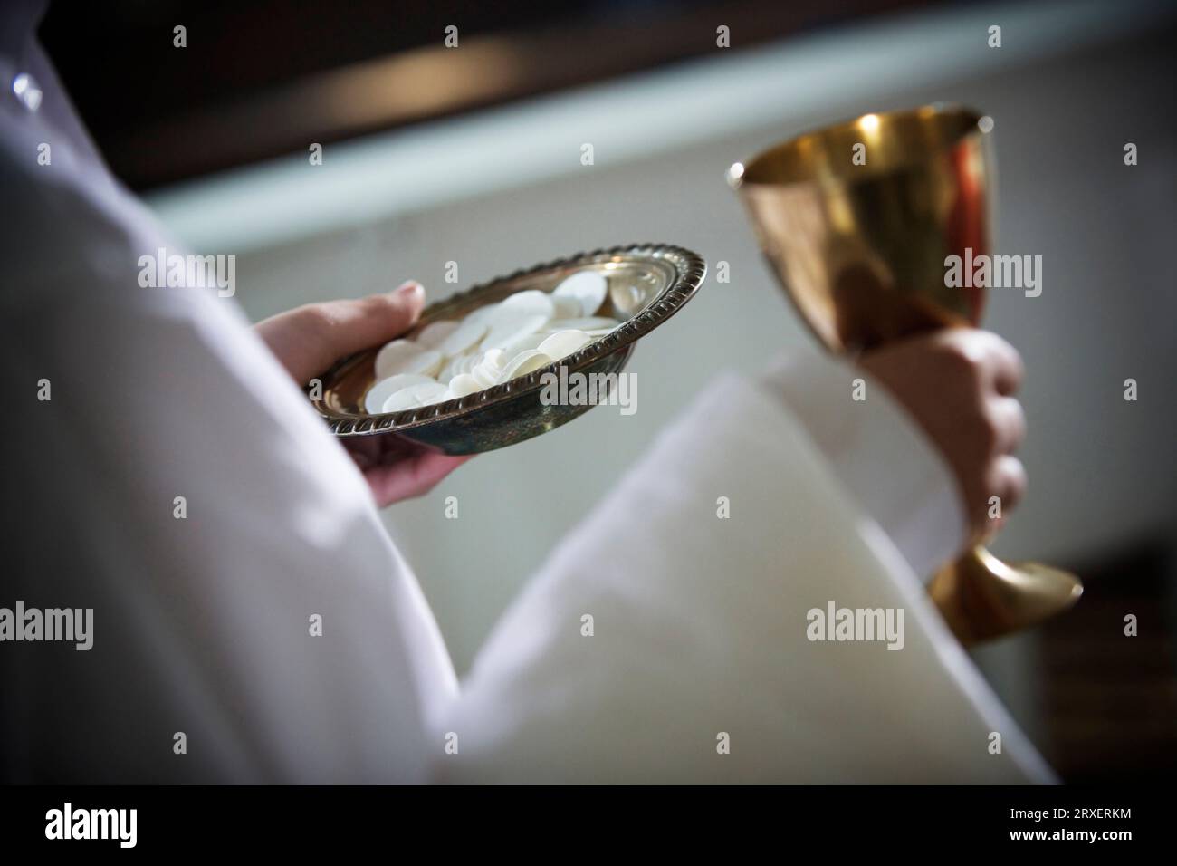 Abgeschnittene Seitenansicht einer Person, die einen Teller und einen Becher hält. Stockfoto