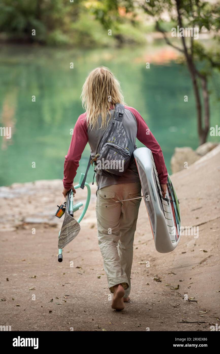 Zu Fuß zum Fluss mit einem SUP und Fliegenrute Stockfoto