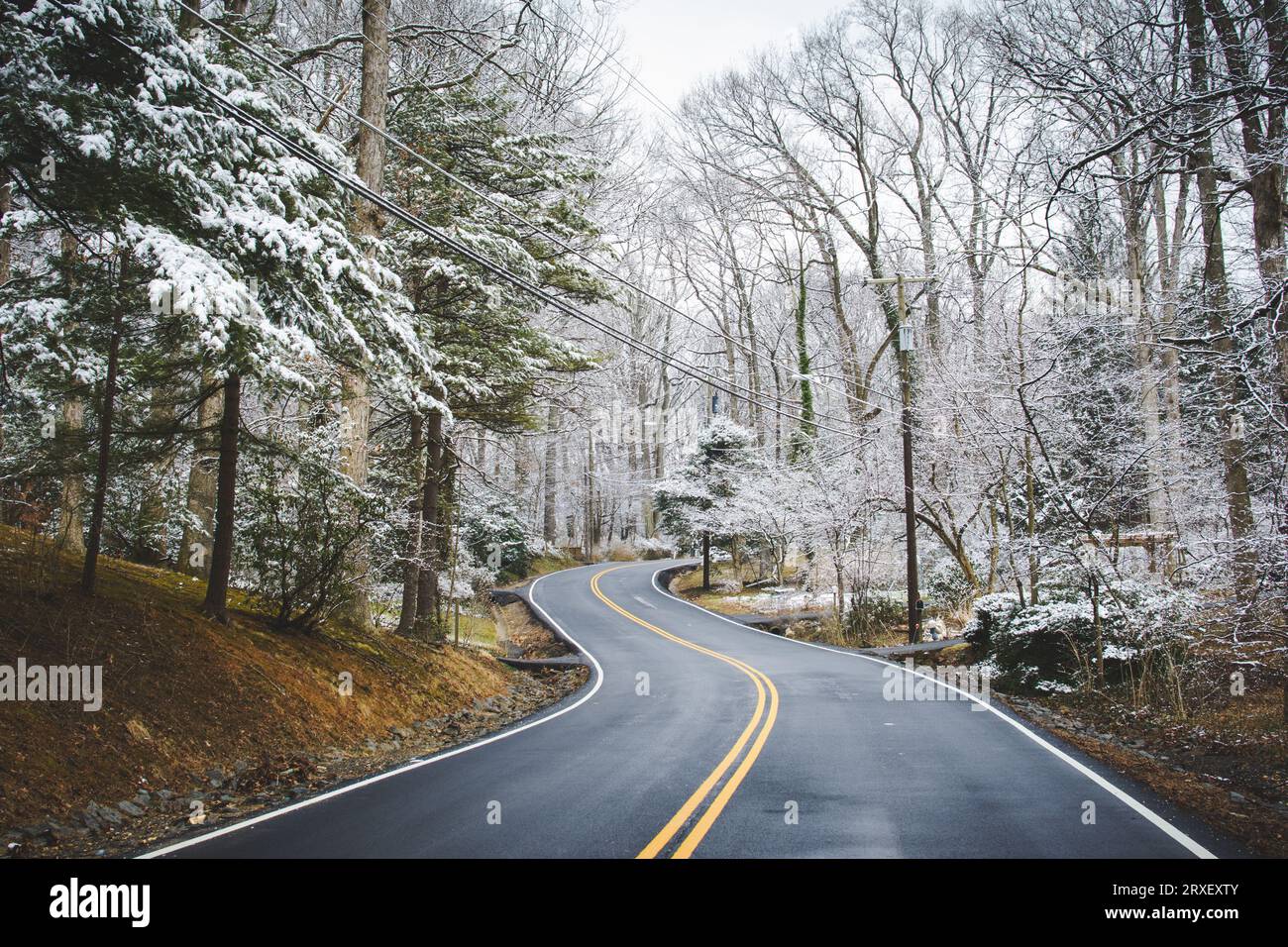 Verschneite Winterszene mit geschwungenen Straßen in ländlicher Landschaft. Stockfoto