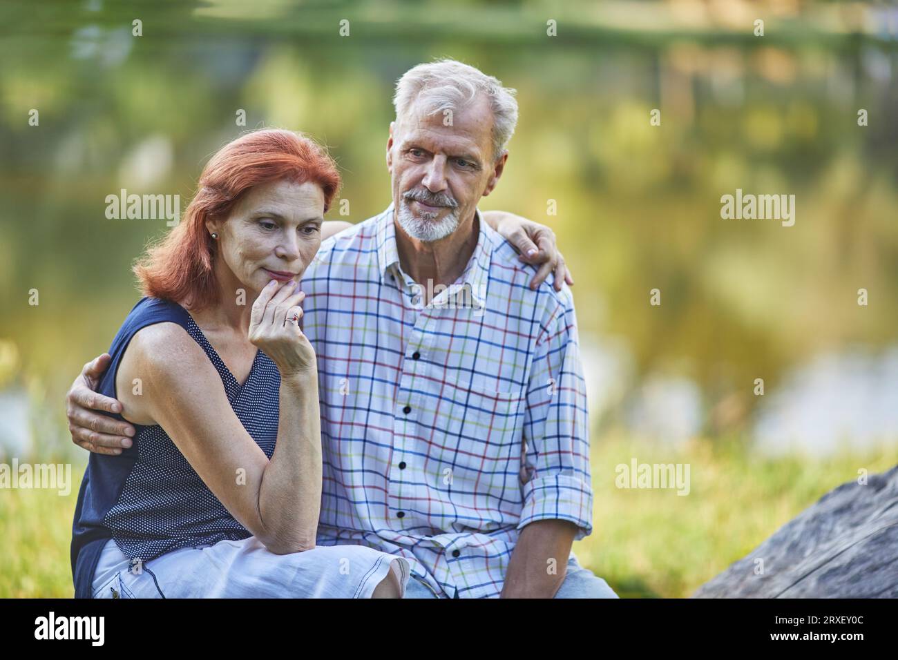 Älterer, nachdenklicher Mann und Frau vor dem Hintergrund des Wassers Stockfoto