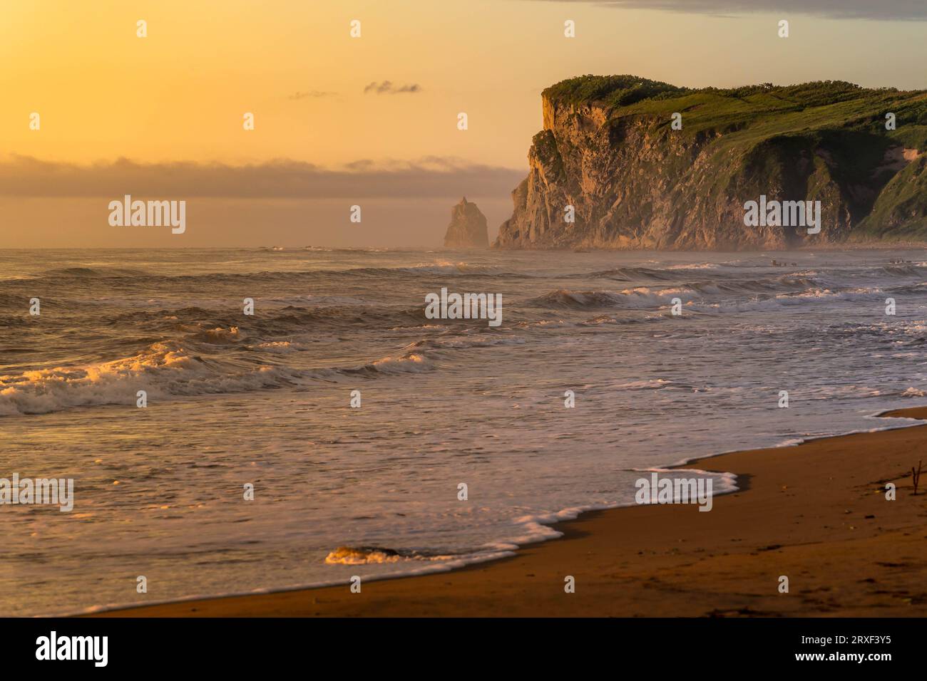 Der malerische Felsen und der Sandstrand das Meer von Japan während des wunderschönen bunten Sonnenaufgangs in der Primorsky-Region im russischen Fernen Osten. Stockfoto
