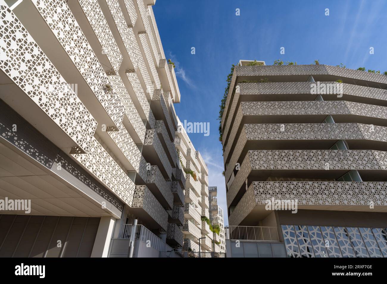 Niedriger Blickwinkel auf weiße Wohngebäude mit zeitgenössischer Architektur im modernen Viertel Port Marianne, Montpellier, Frankreich Stockfoto