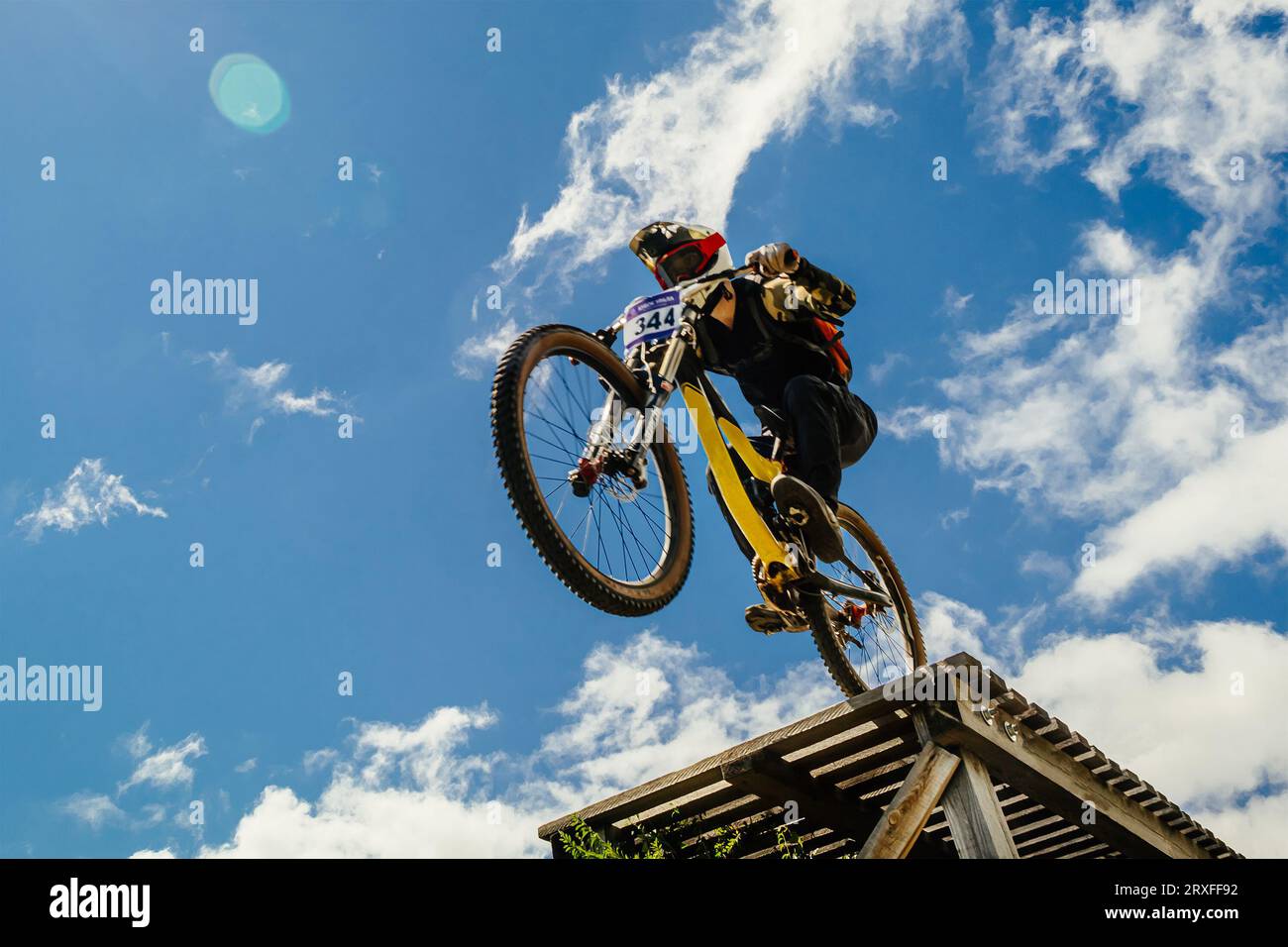 Athlet Mountainbiker am Rande des Abstiegs im Hintergrund des blauen Himmels Stockfoto