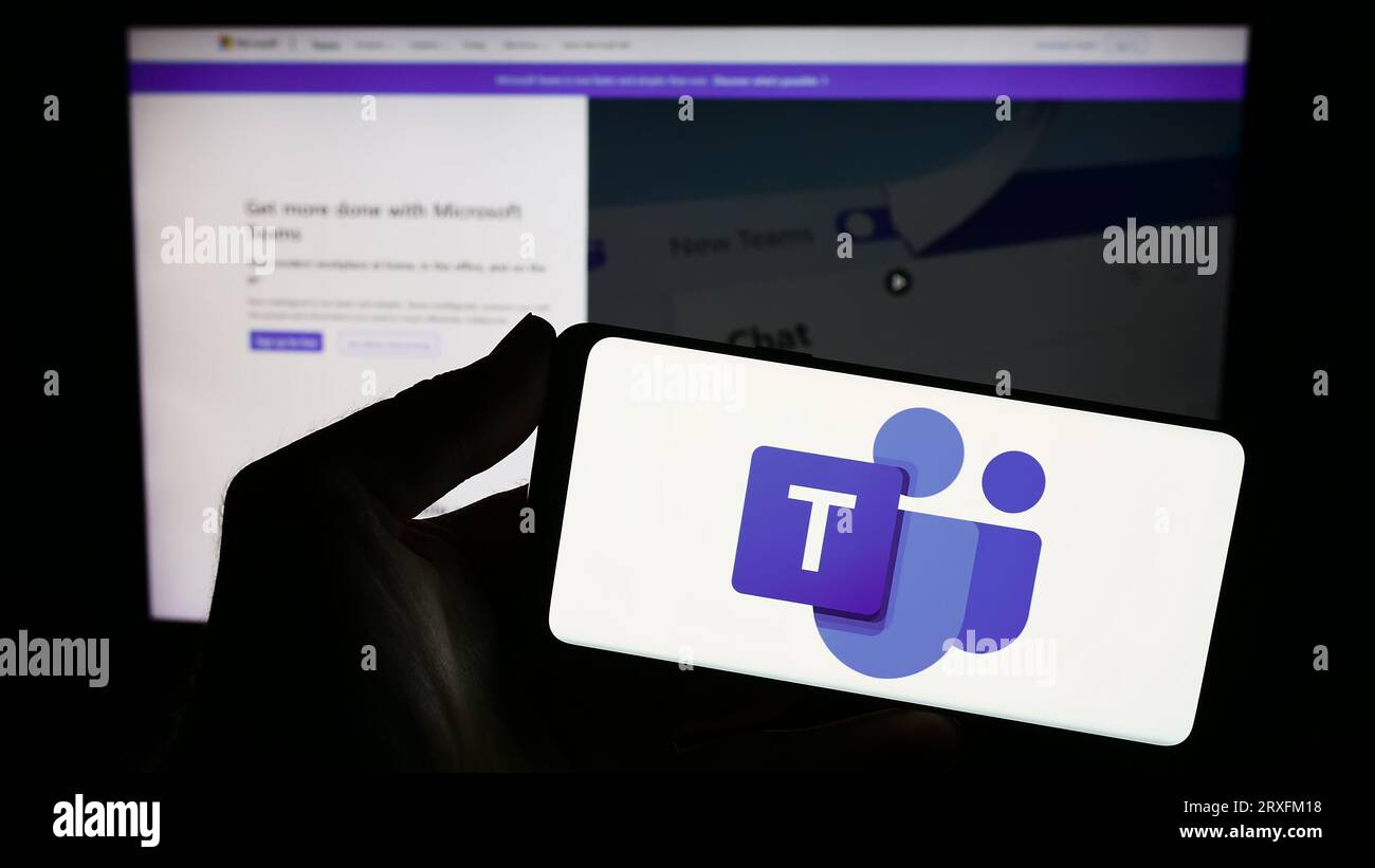 Person, die ein Smartphone mit dem Logo der Business Communication Platform hält Microsoft Teams auf dem Bildschirm vor der Website. Konzentrieren Sie sich auf das Display des Telefons. Stockfoto