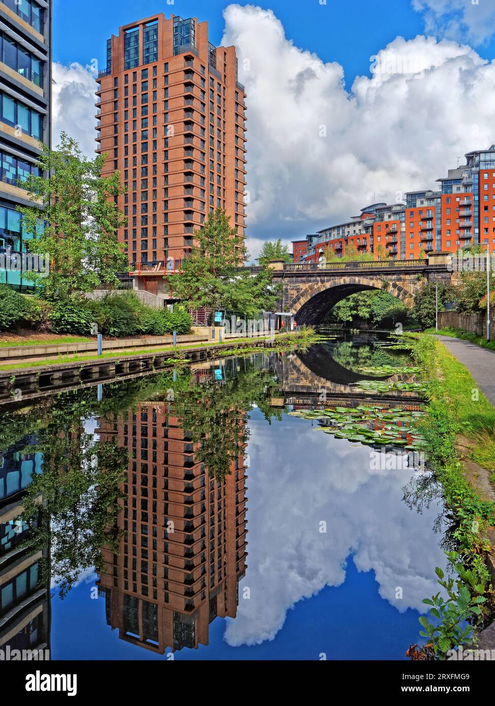 Großbritannien, West Yorkshire, Leeds, Brücke über Leeds und Liverpool Canal mit modernen Hochhausapartmentblocks im Hintergrund. Stockfoto