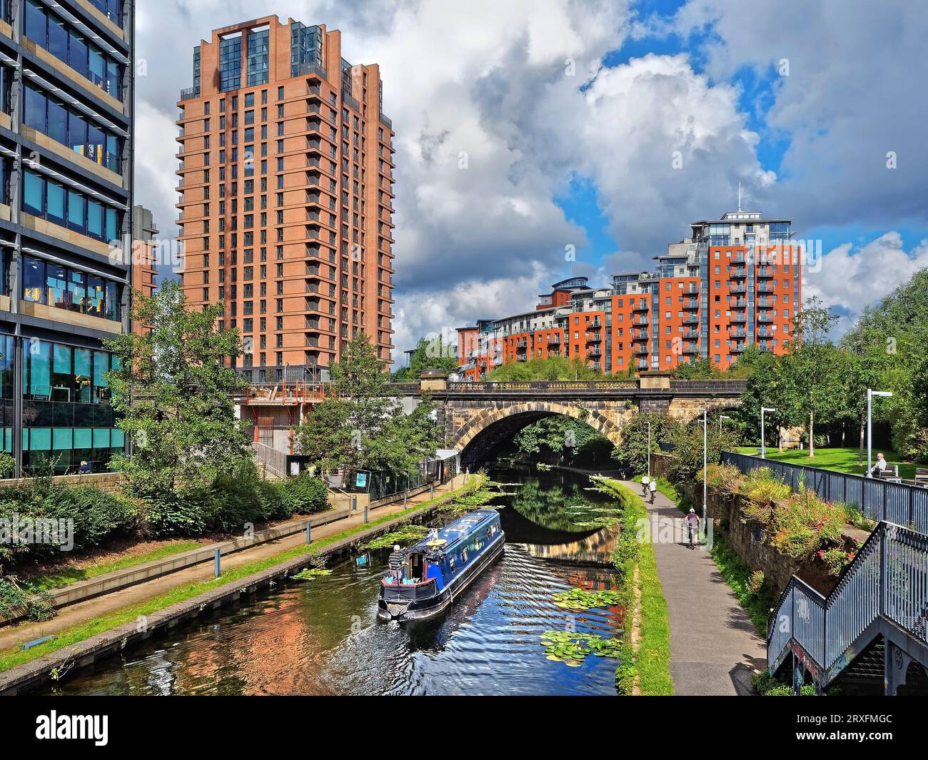 Großbritannien, West Yorkshire, Leeds, Brücke über Leeds und Liverpool Canal mit modernen Hochhausapartmentblocks im Hintergrund. Stockfoto