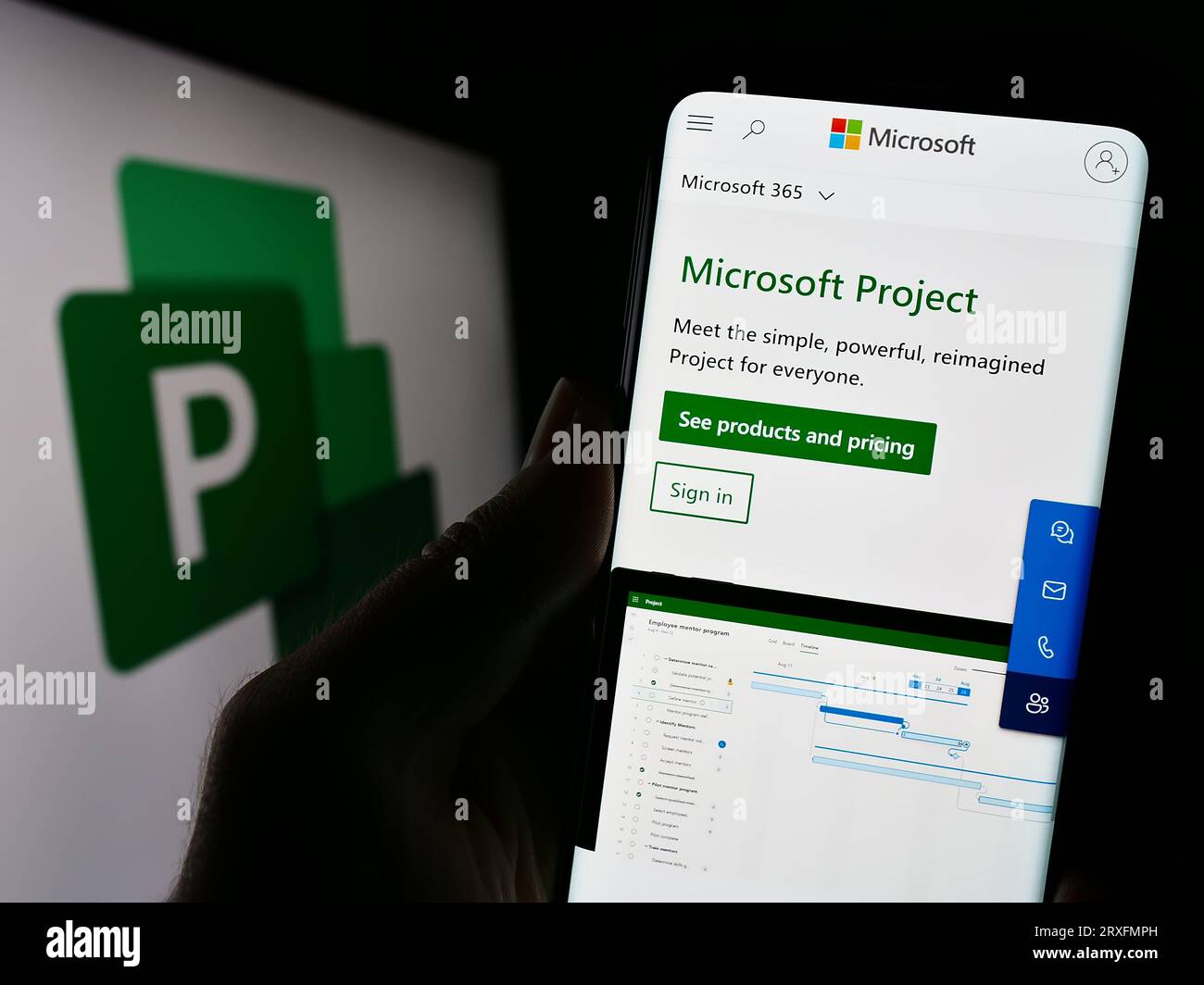 Person, die ein Mobiltelefon mit einer Webseite der Projektmanagementsoftware Microsoft Project auf dem Bildschirm mit Logo hält. Konzentrieren Sie sich auf die Mitte der Telefonanzeige. Stockfoto