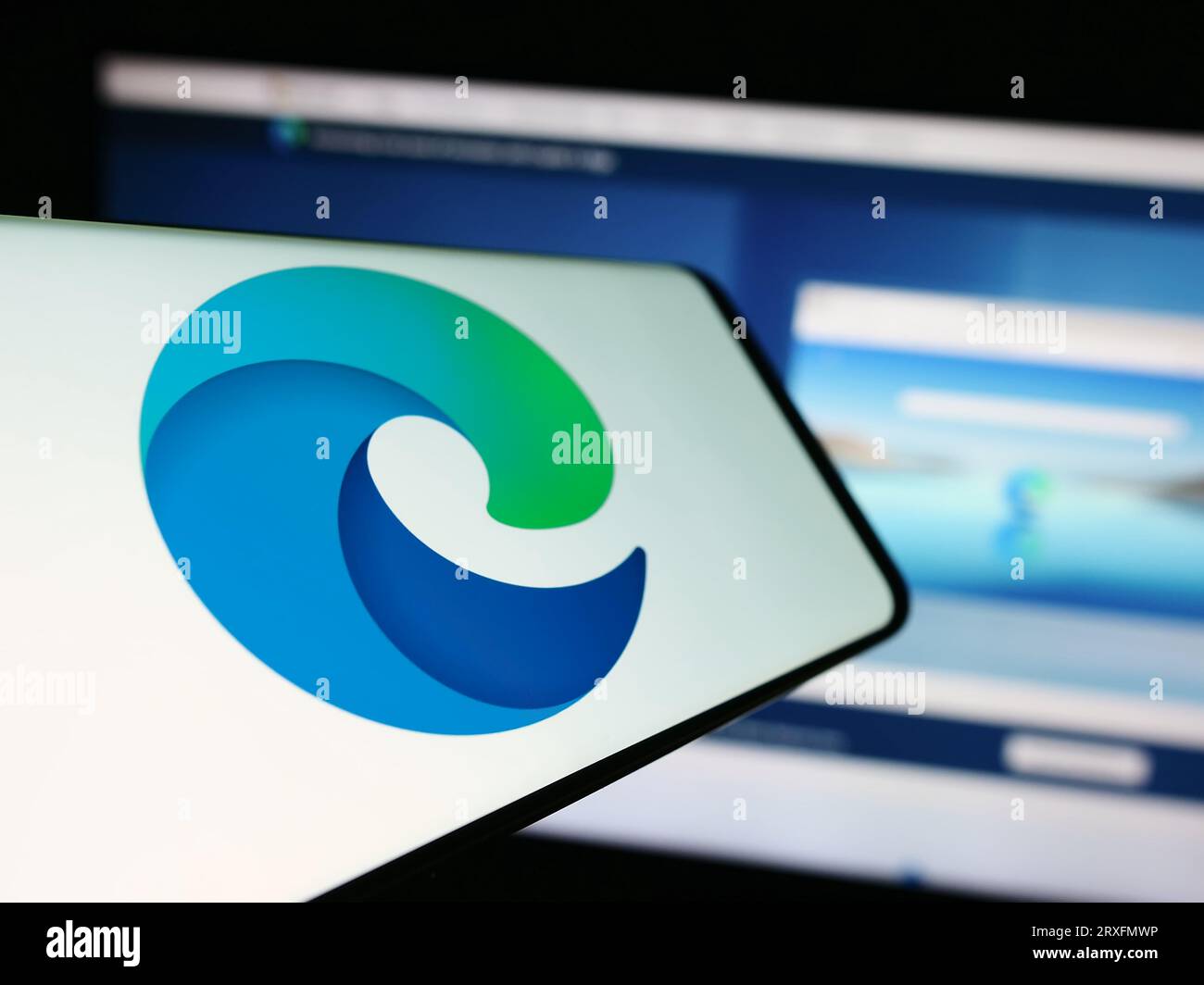Mobiltelefon mit dem Logo des Webbrowsers Microsoft Edge auf dem Bildschirm vor der Business-Website. Konzentrieren Sie sich auf die Mitte der Telefonanzeige. Stockfoto