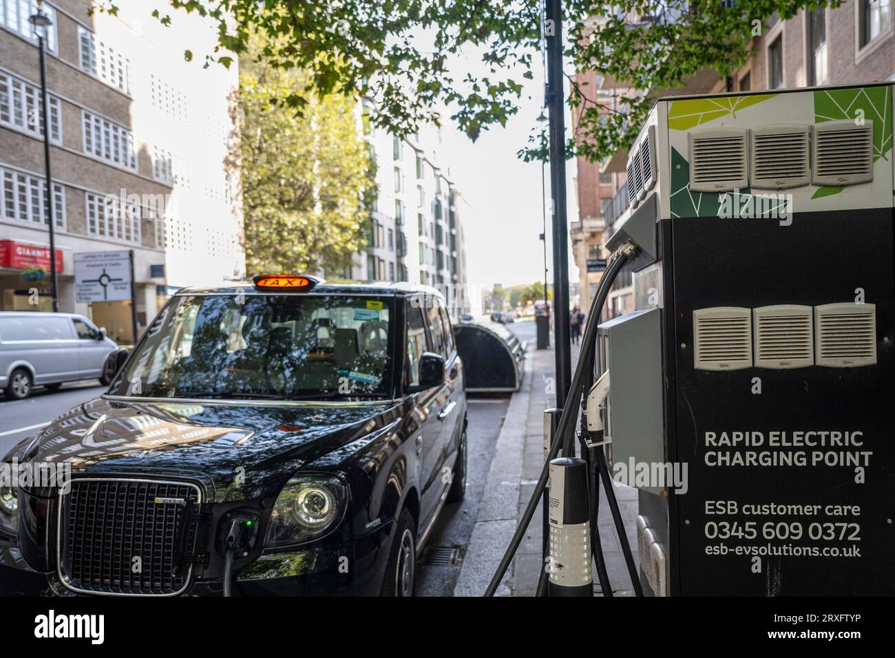 London, Großbritannien. 25. September 2023. Ein Taxi an einer Ladestation für Elektroautos in Westminster. Der Verband der europäischen Automobilhersteller (ACEA) hat erklärt, dass die neuen Brexit-Handelsregeln vorsehen, dass Elektrofahrzeuge Batterien entweder im Vereinigten Königreich oder in der EU produzieren lassen müssen. Autos, die die Kriterien nicht erfüllen, müssen in den nächsten drei Jahren 10 % der Gebühren entrichten, die den europäischen Herstellern 3,75 Mrd. £ Kosten. Hersteller sagen, dass sie nicht bereit sind, Batteriefabriken zu produzieren, und die Kosten der Zölle werden die Verbraucherpreise erhöhen. Quelle: Stephen Chung / Alamy Live News Stockfoto