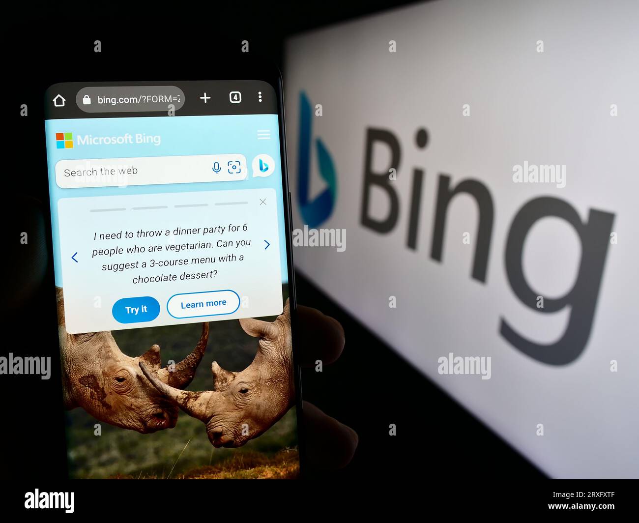 Person, die ein Mobiltelefon mit der Webseite der Web-Suchmaschine Microsoft Bing auf dem Bildschirm vor dem Logo hält. Konzentrieren Sie sich auf die Mitte der Telefonanzeige. Stockfoto