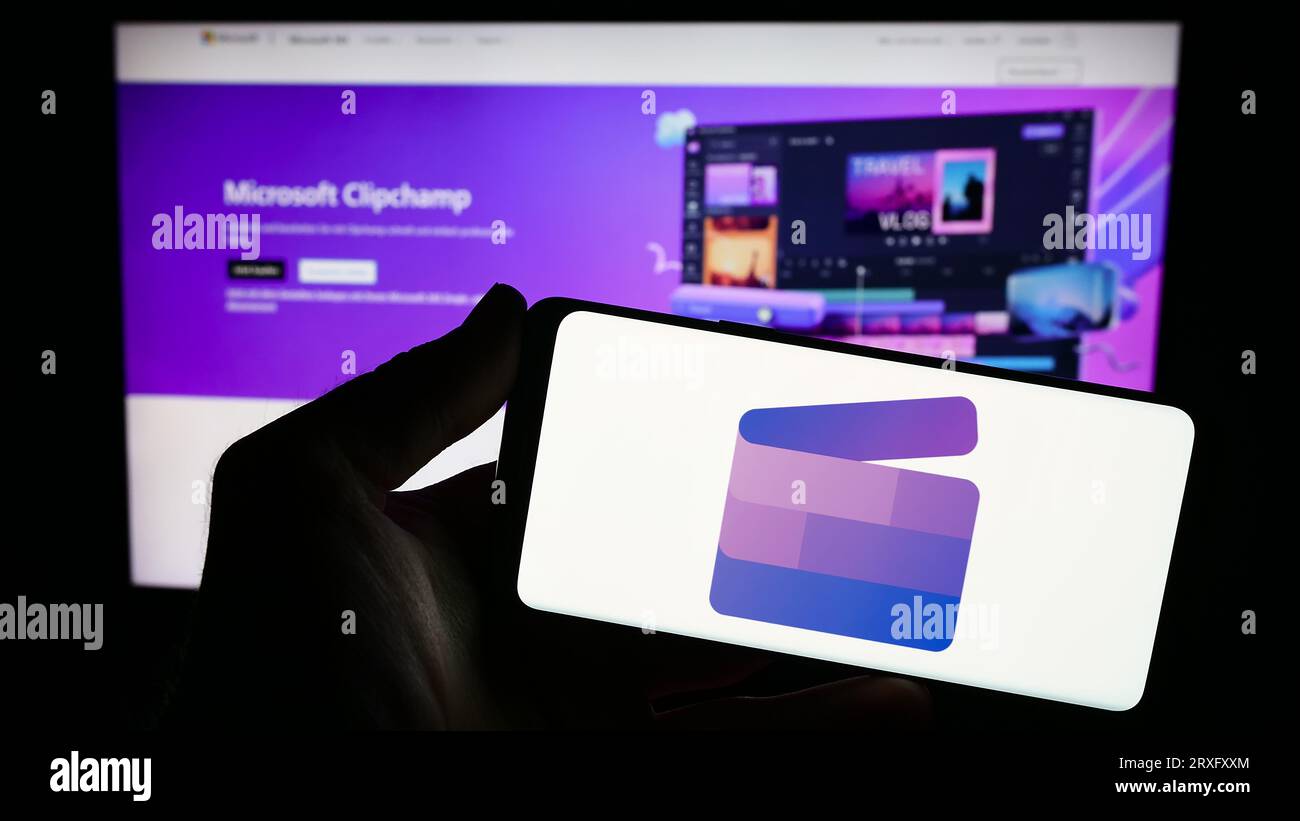 Person, die ein Smartphone mit dem Logo der Videobearbeitungssoftware Clipchamp (Microsoft) auf dem Bildschirm vor der Website hält. Konzentrieren Sie sich auf das Display des Telefons. Stockfoto