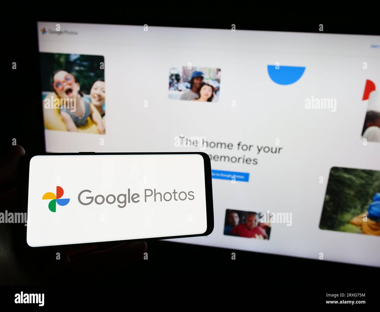Person mit Smartphone mit Logo der Bildspeicherplattform Google Photos auf dem Bildschirm vor der Website. Konzentrieren Sie sich auf das Display des Telefons. Stockfoto Person mit Smartphone mit Logo der Bildspeicherplattform Google Photos auf dem Bildschirm vor der Website. Konzentrieren Sie sich auf das Display des Telefons. Stockfoto