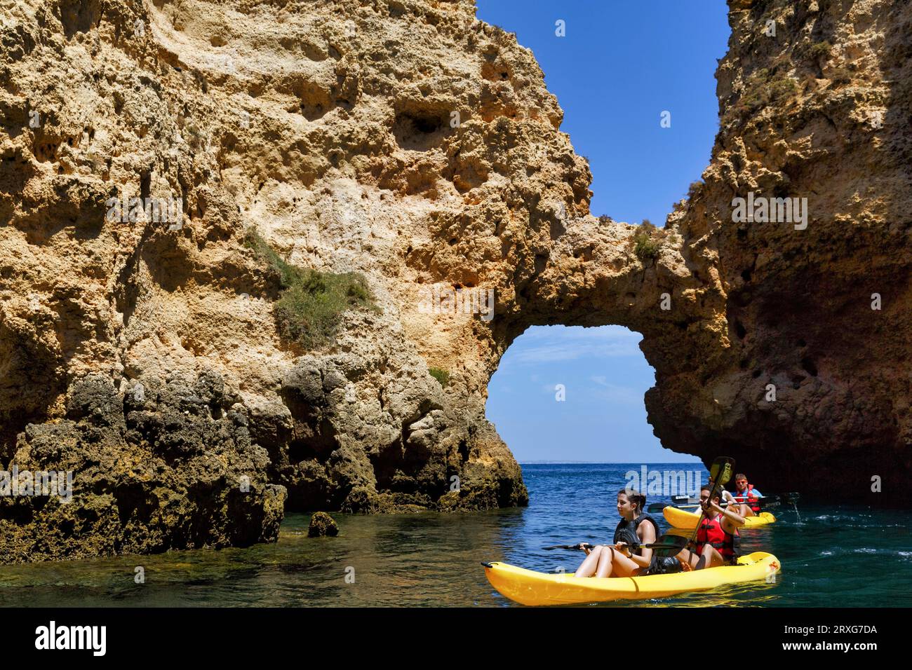 Touristen Kajak in Ponta da Piedade, Klippenlandschaft, Sandsteinklippen, Felstor, Atlantik, Lagos, Algarve, Portugal Stockfoto